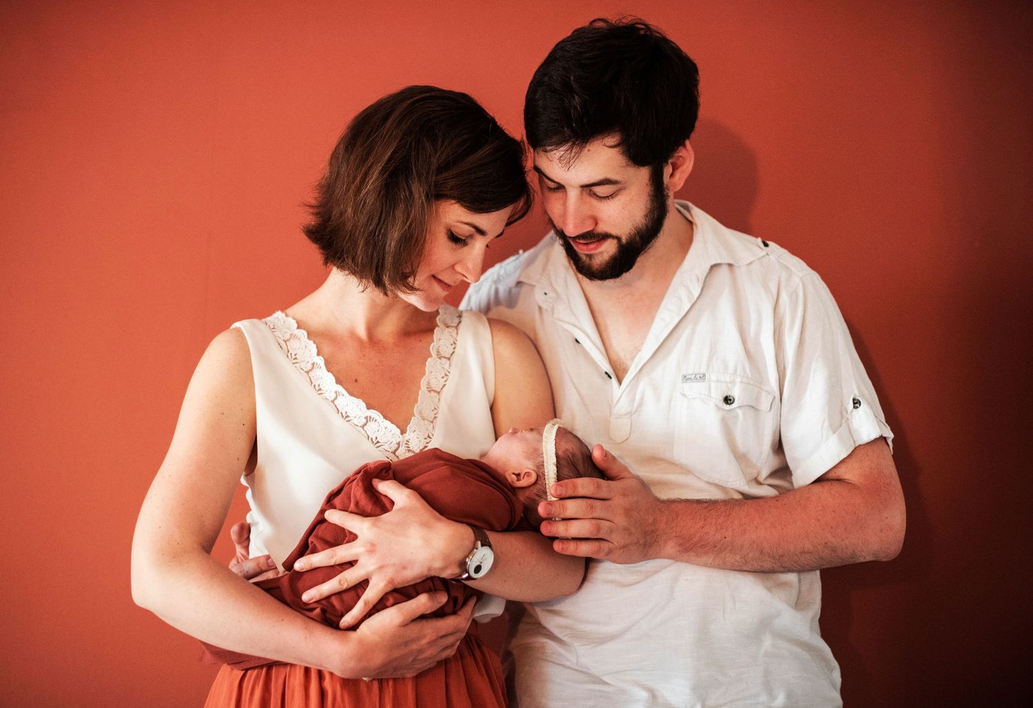 Intimate family moments captured against a warm terracotta colored background.