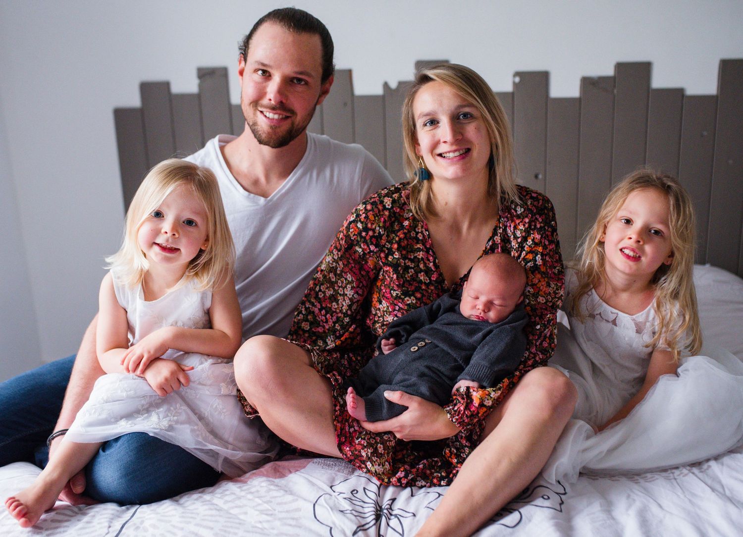 Family lifestyle photo series showing joyful moments together on bed.