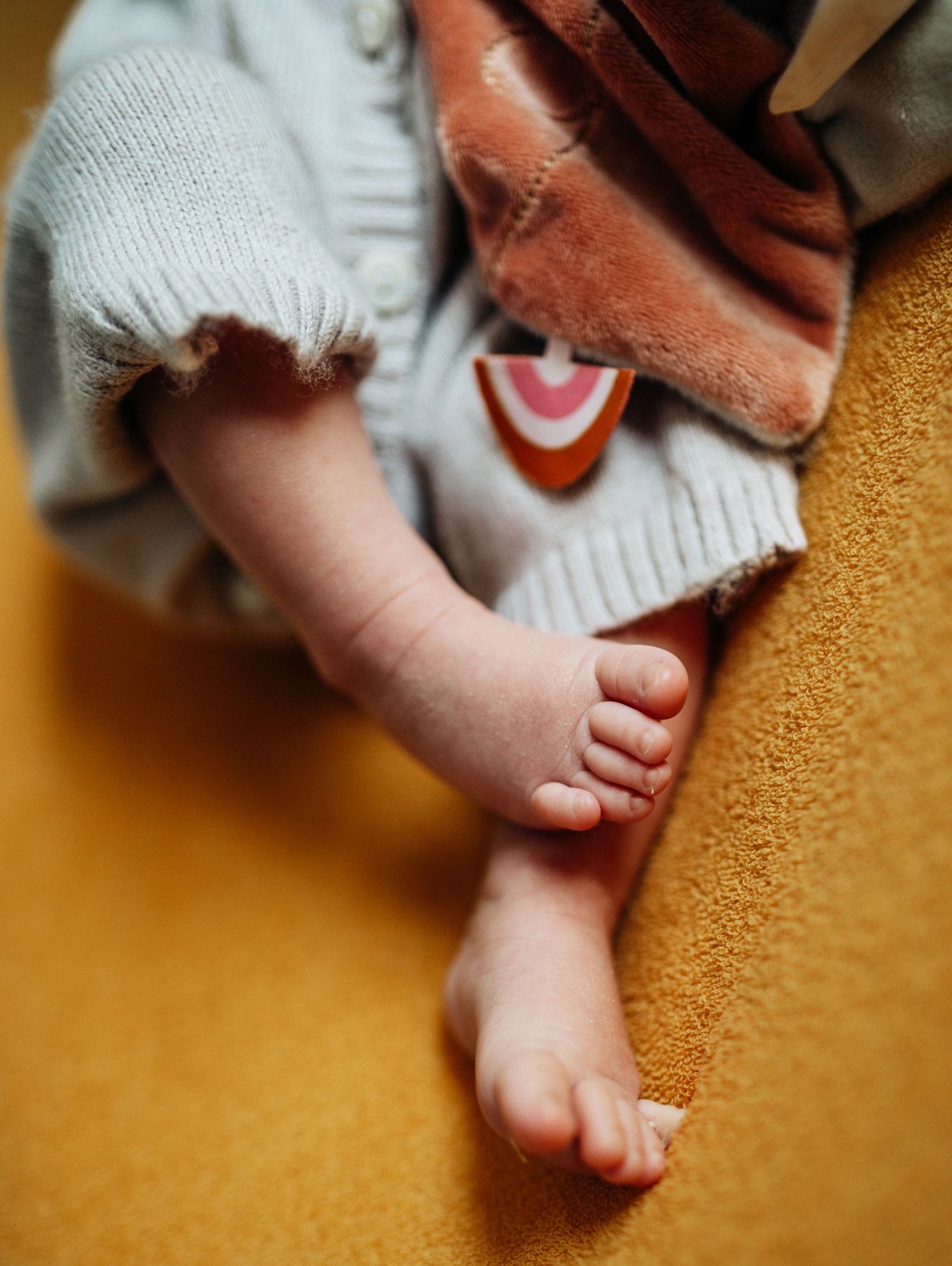 Close-up shots of tiny baby feet against a warm orange background.