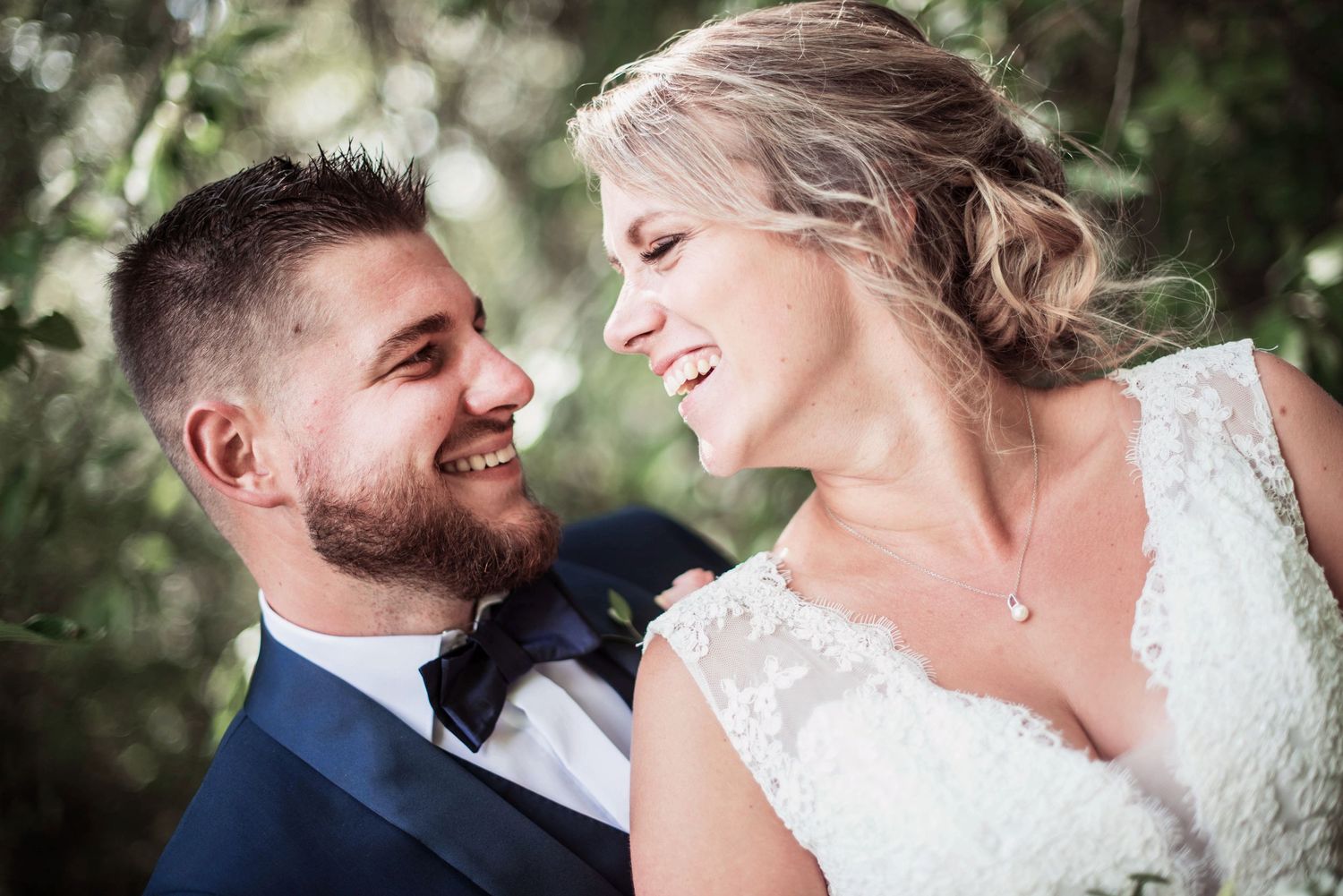 Romantic wedding portraits captured in a natural outdoor setting with soft lighting.
