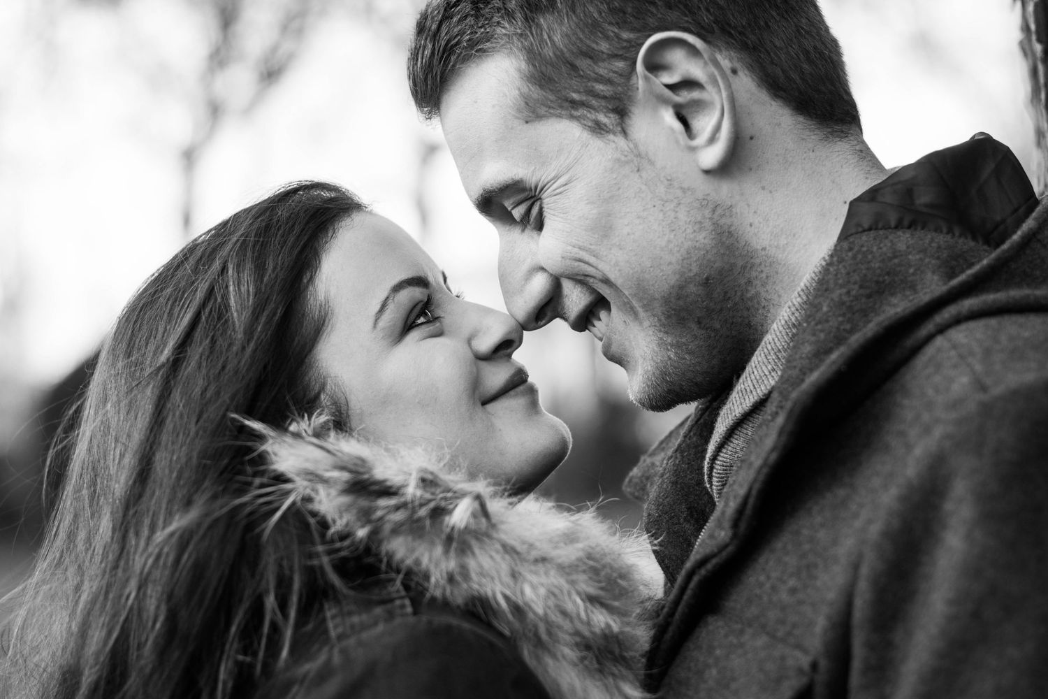 Intimate black and white portrait of couple sharing tender moment.