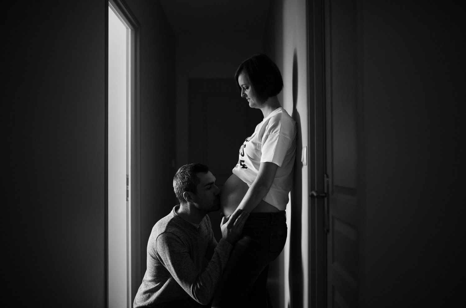 Silhouette of a couple sharing an intimate moment in a dark hallway.