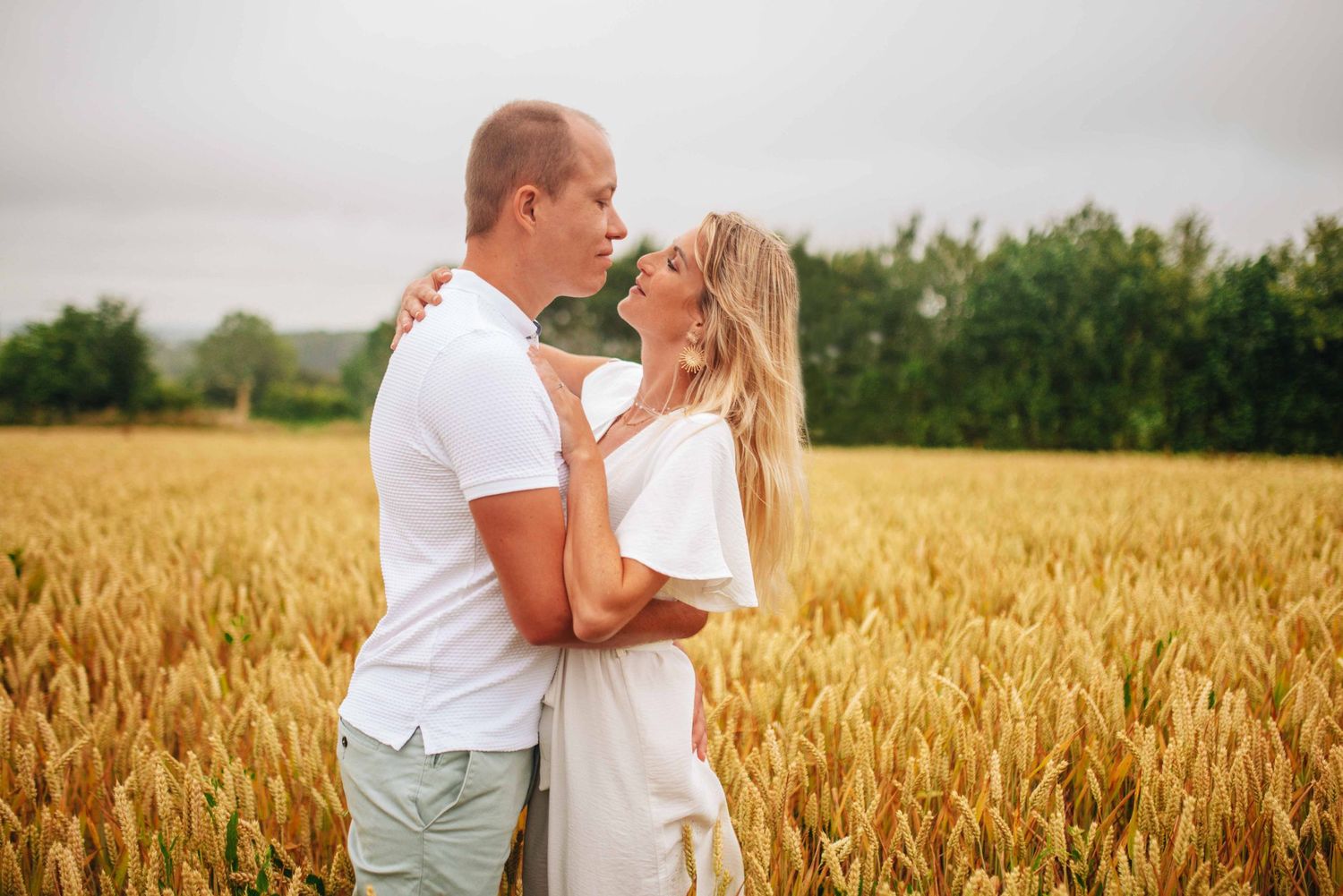 A series of romantic photos showing a couple embracing in a golden wheat field at sunset.