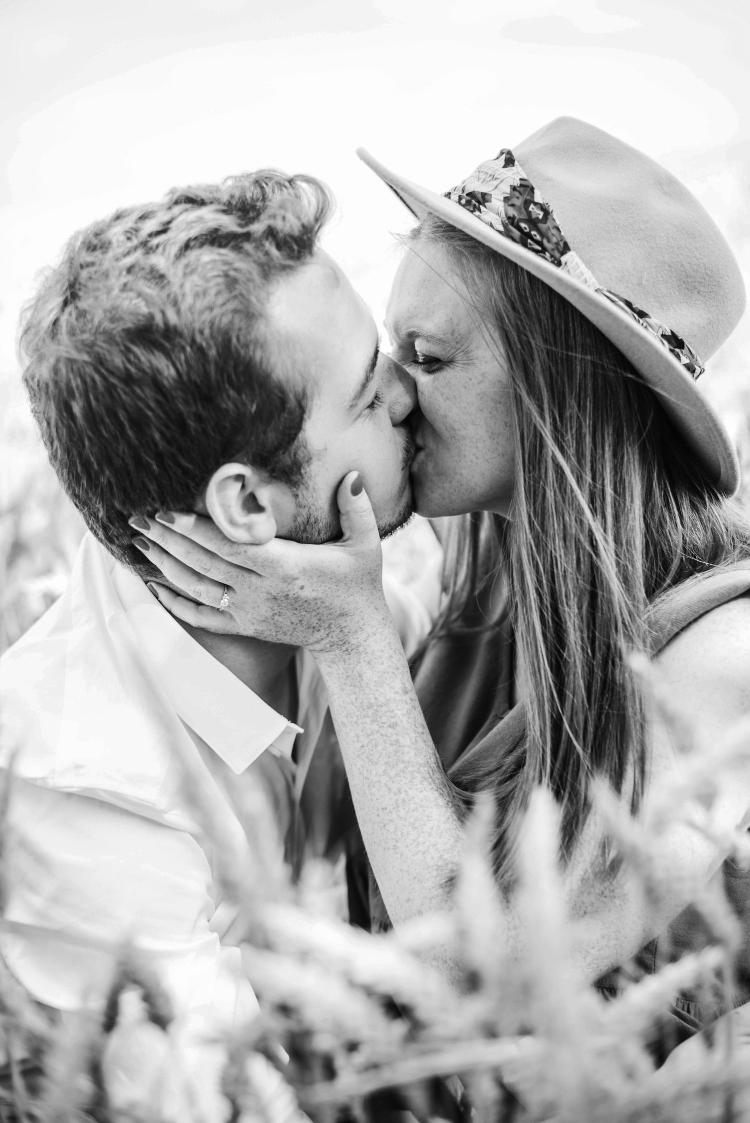 Series of black and white photos showing tender kisses between a couple wearing casual summer attire.
