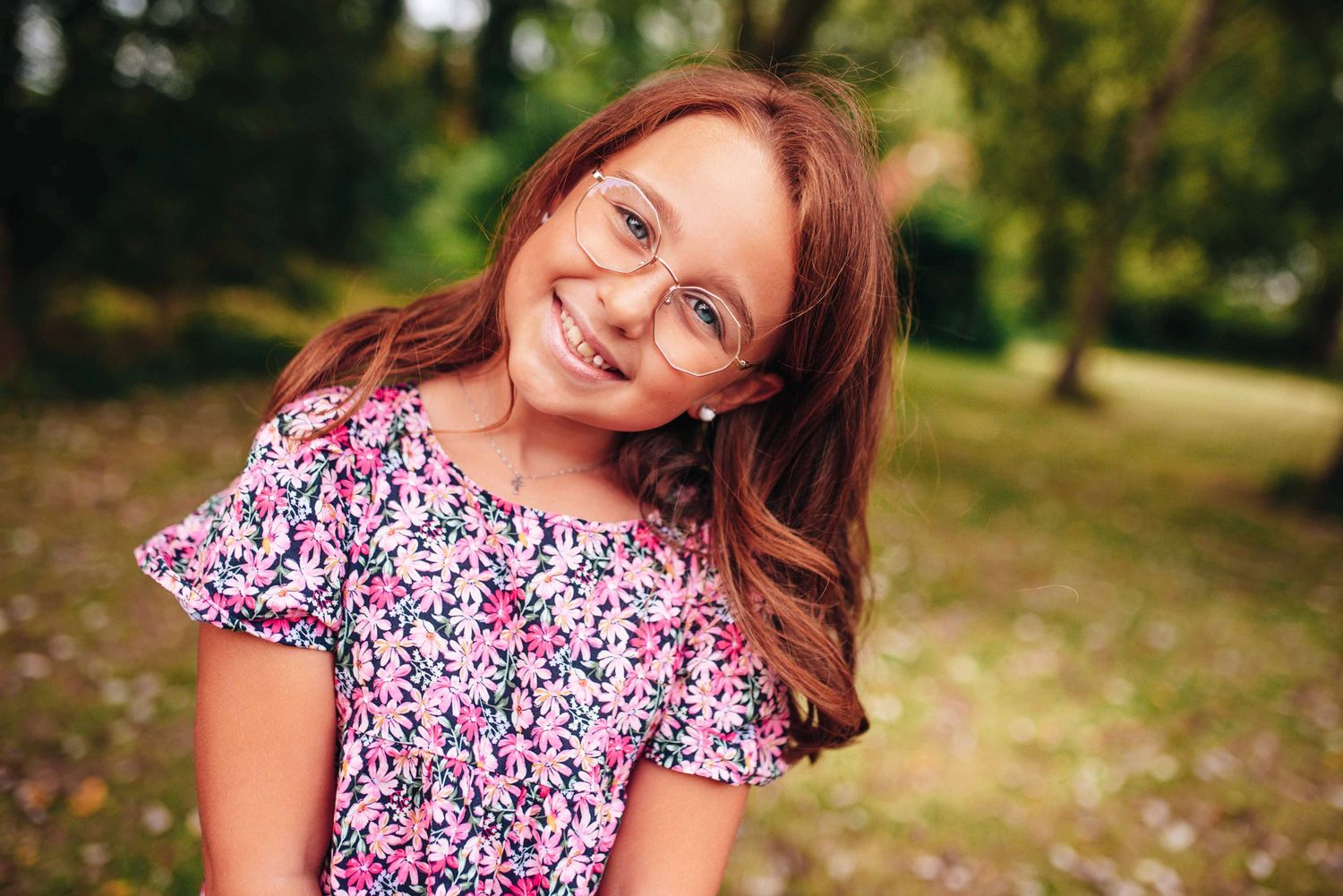 Outdoor portrait session in a park with natural lighting and greenery.