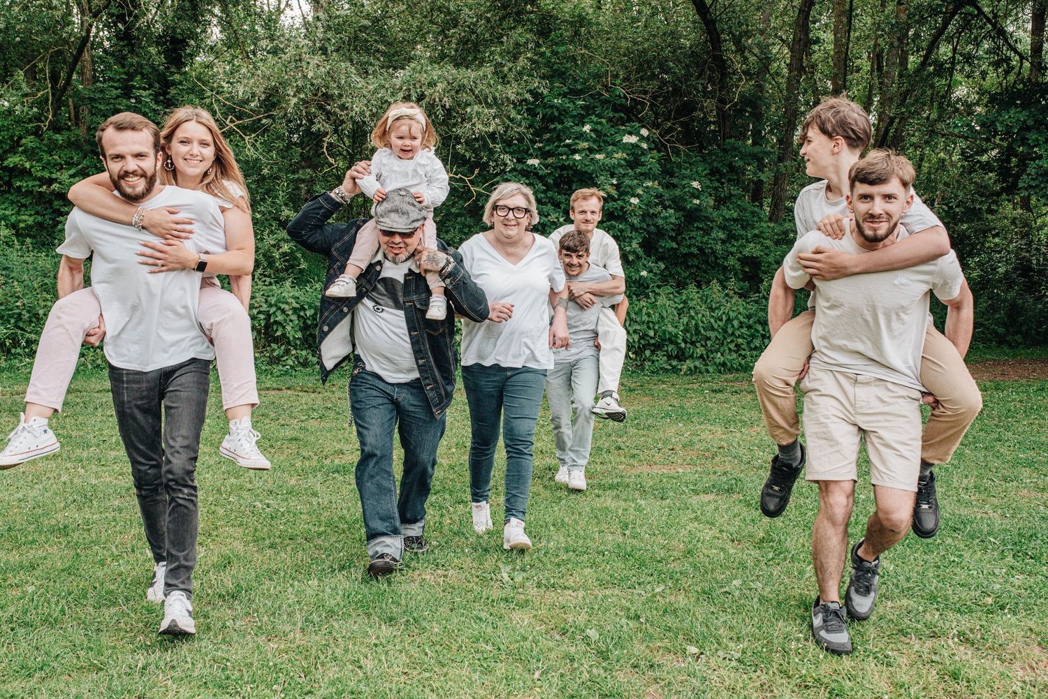 Candid shots of people running and playing together on grassy lawn during outdoor gathering.