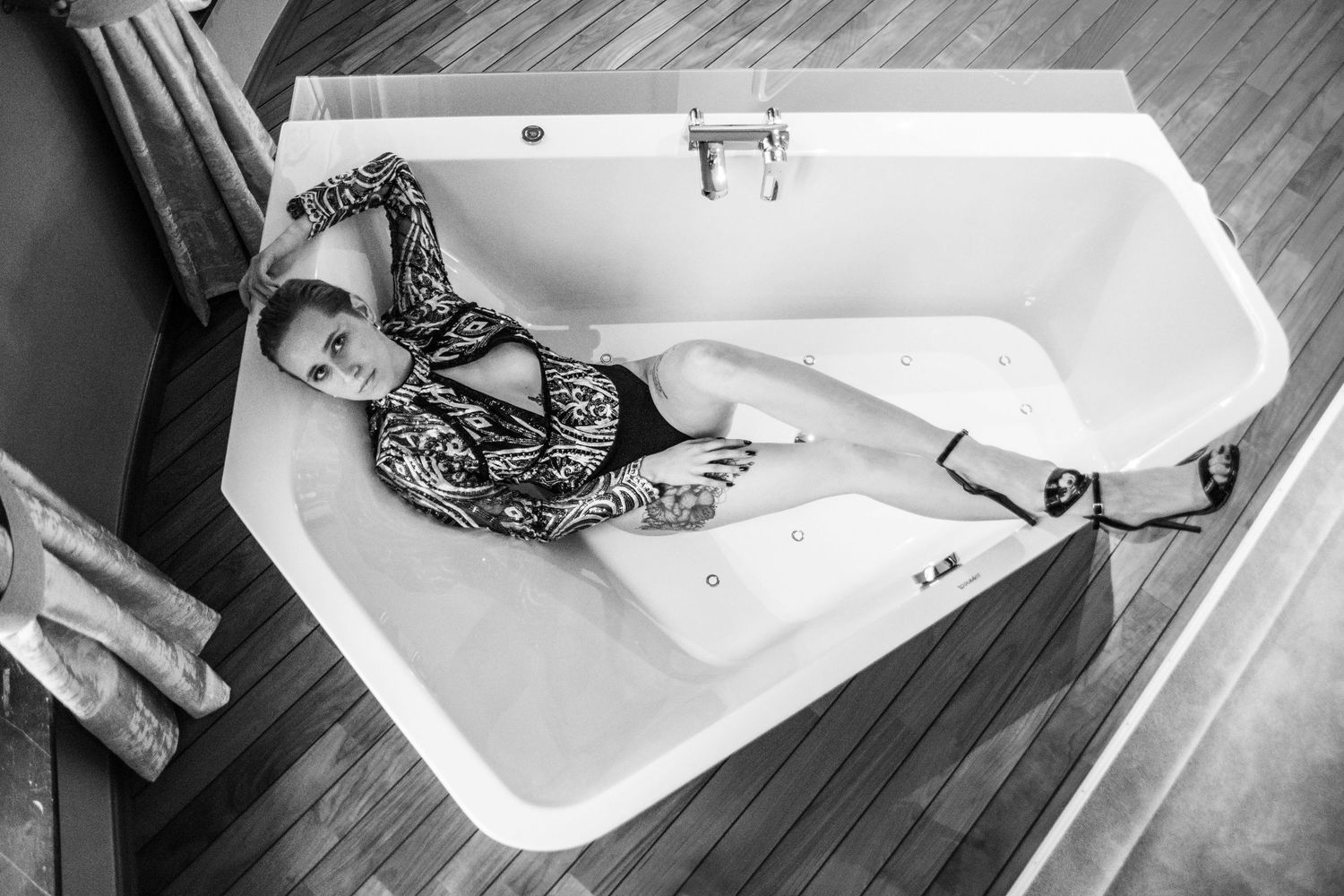 Artistic black and white boudoir photo series showing a woman in lingerie posing on a bed.
