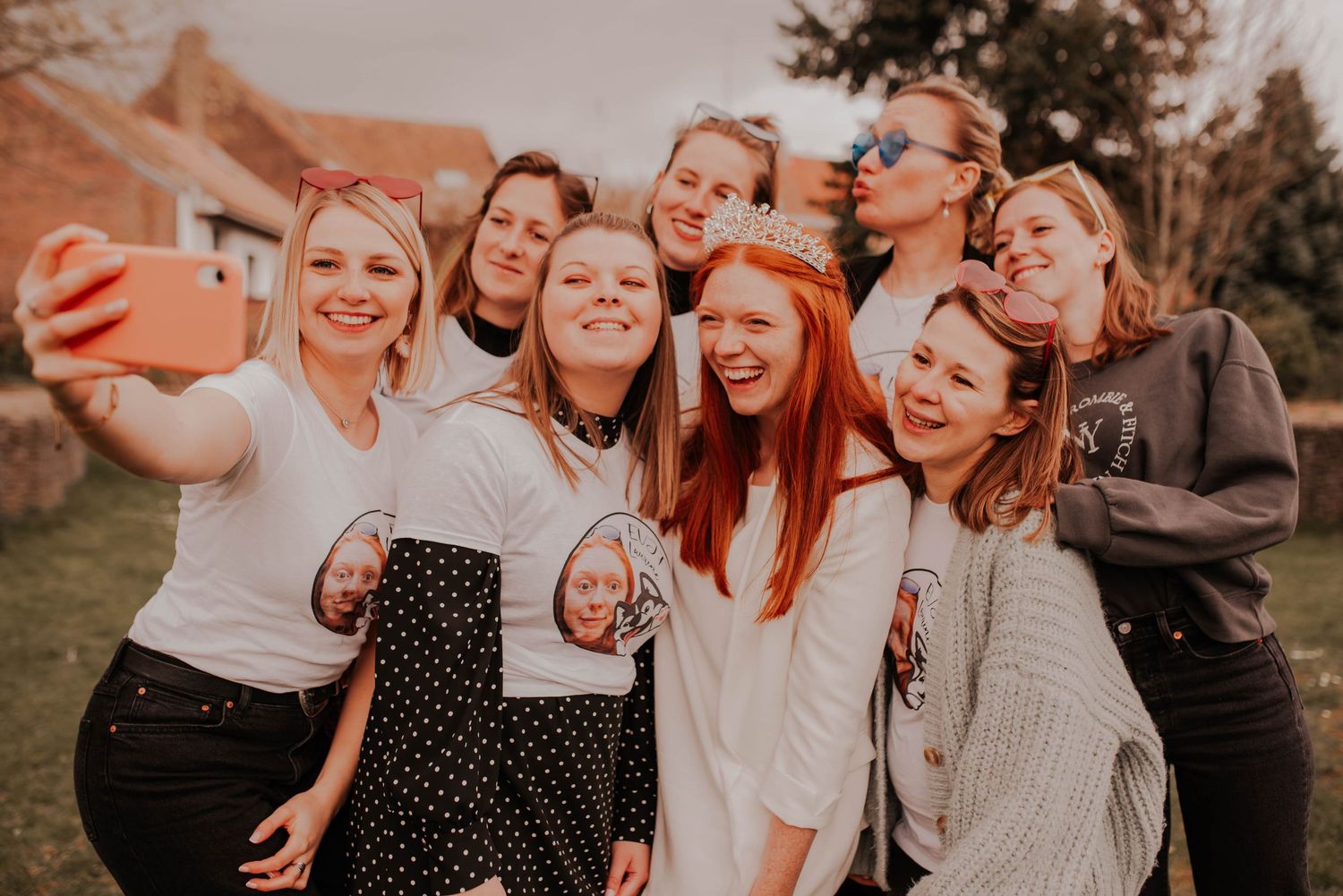 Friends taking a selfie together outdoors while making playful expressions.