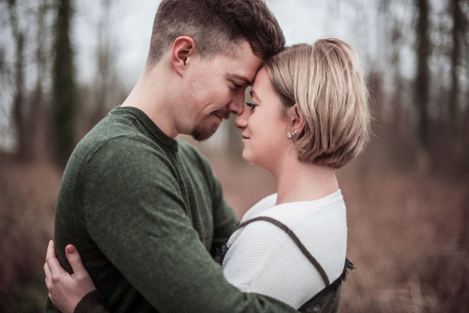Intimate couple portraits showing tender moments in a winter forest setting.