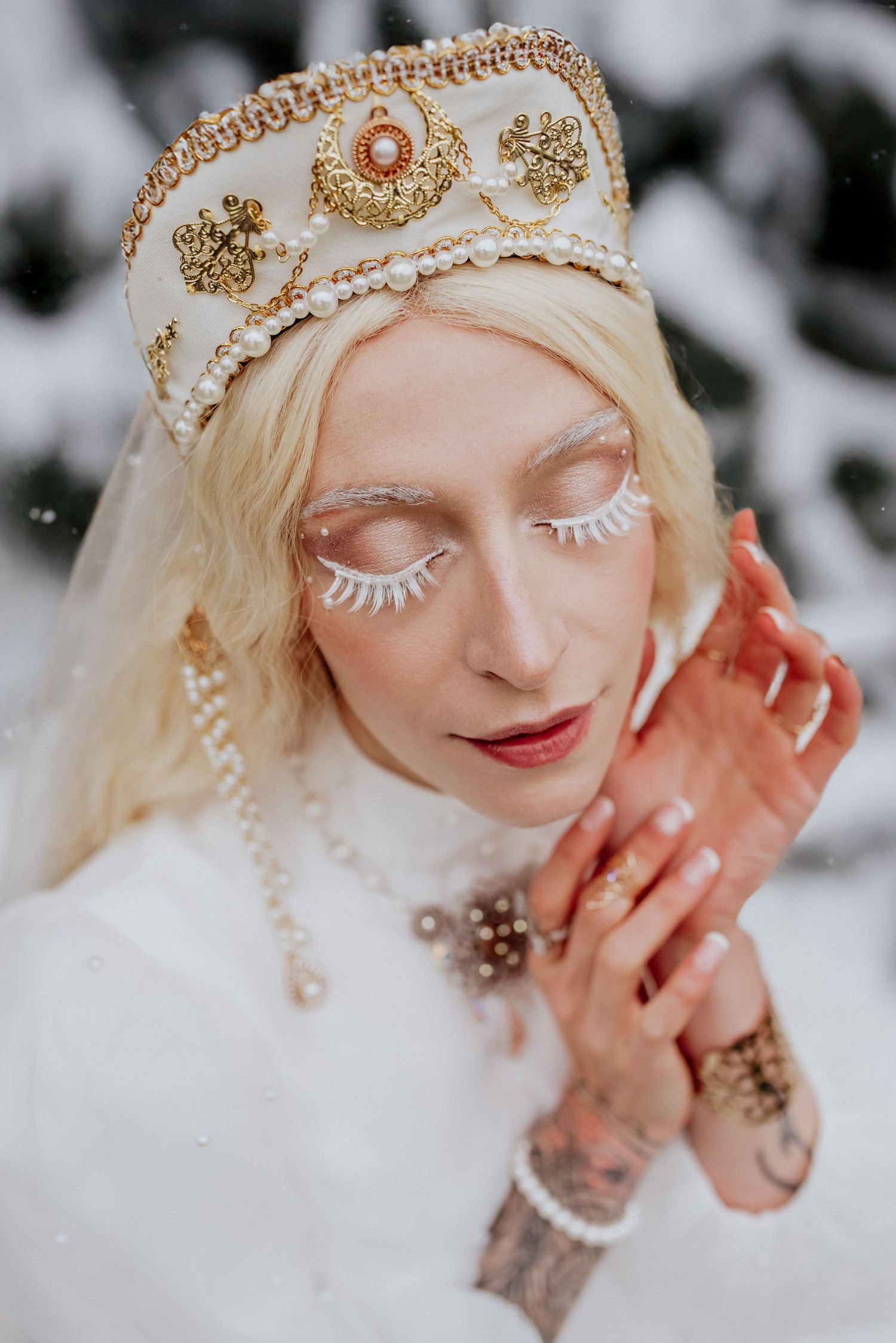 Delicate close-up portrait showcasing intricate gold crown details and winter makeup artistry.