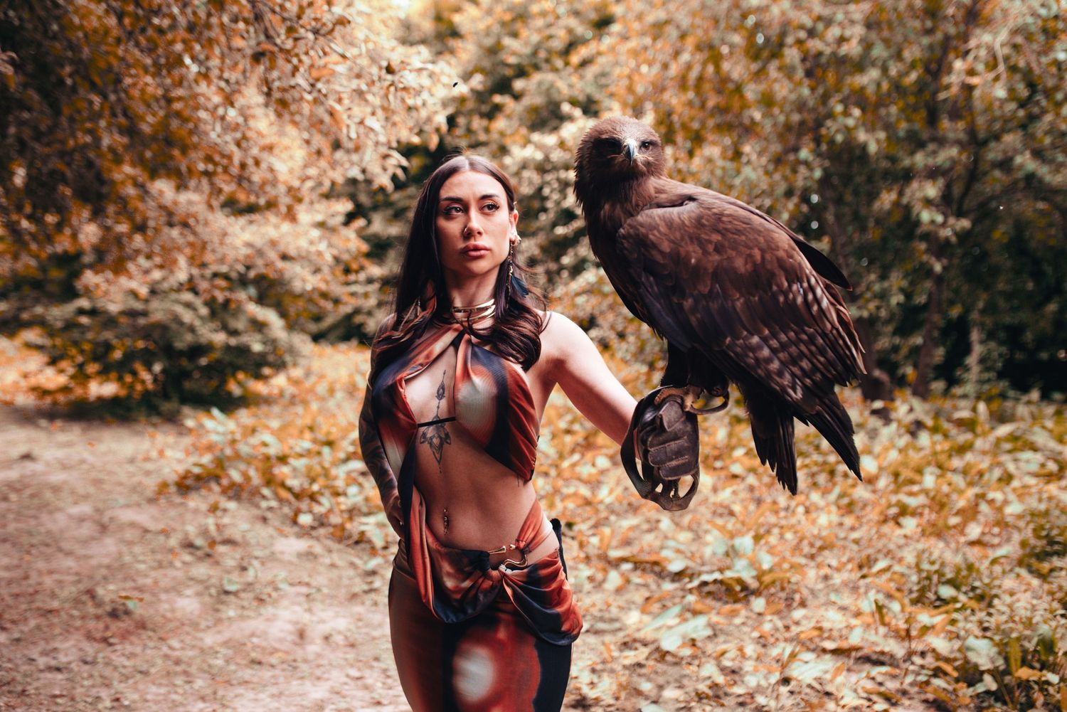 Person in medieval costume walking with horse through autumn forest setting.