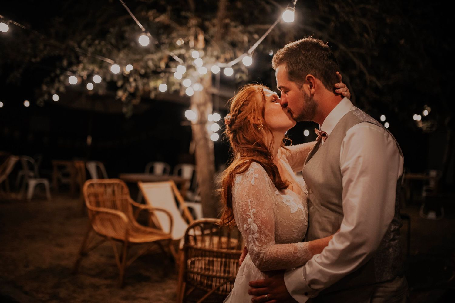 Evening wedding reception with romantic string lights creating an intimate atmosphere.