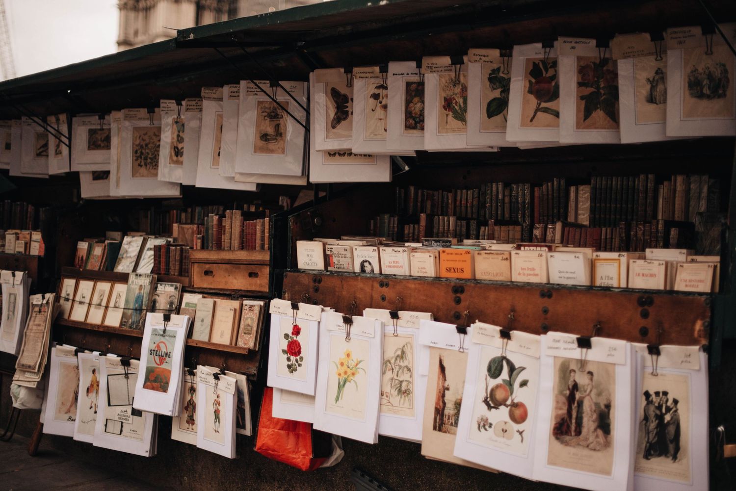 A long display of artwork and sketches hanging from strings against a dark background.