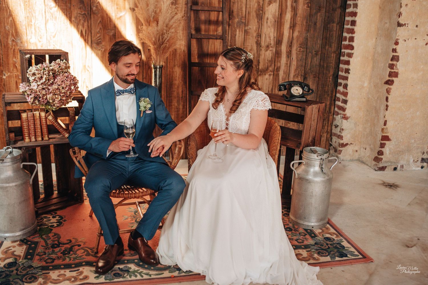 Rustic barn wedding celebration with vintage milk jugs and wooden interior details.