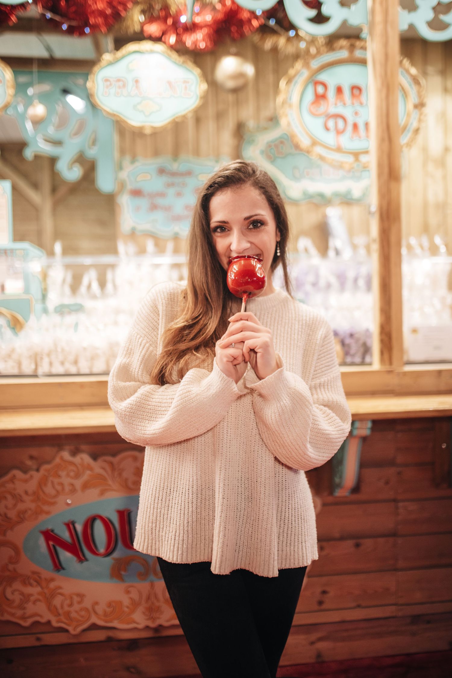 Cozy winter portrait in cream sweater against carnival backdrop with vintage decorations.