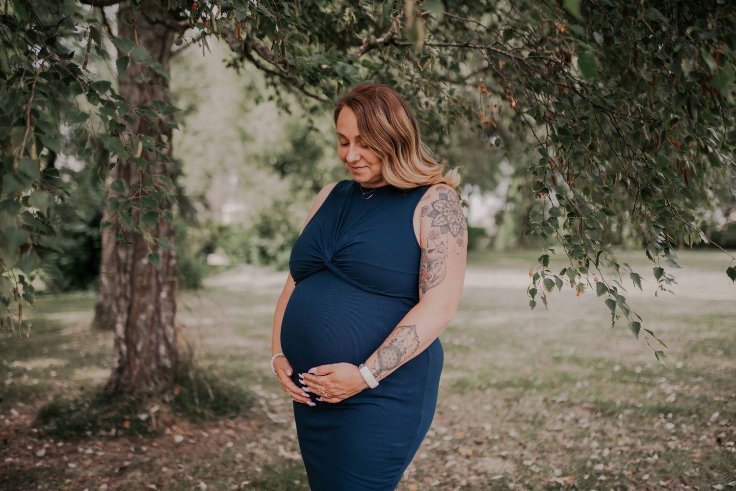 A series of outdoor maternity photos taken in a park with trees in the background.