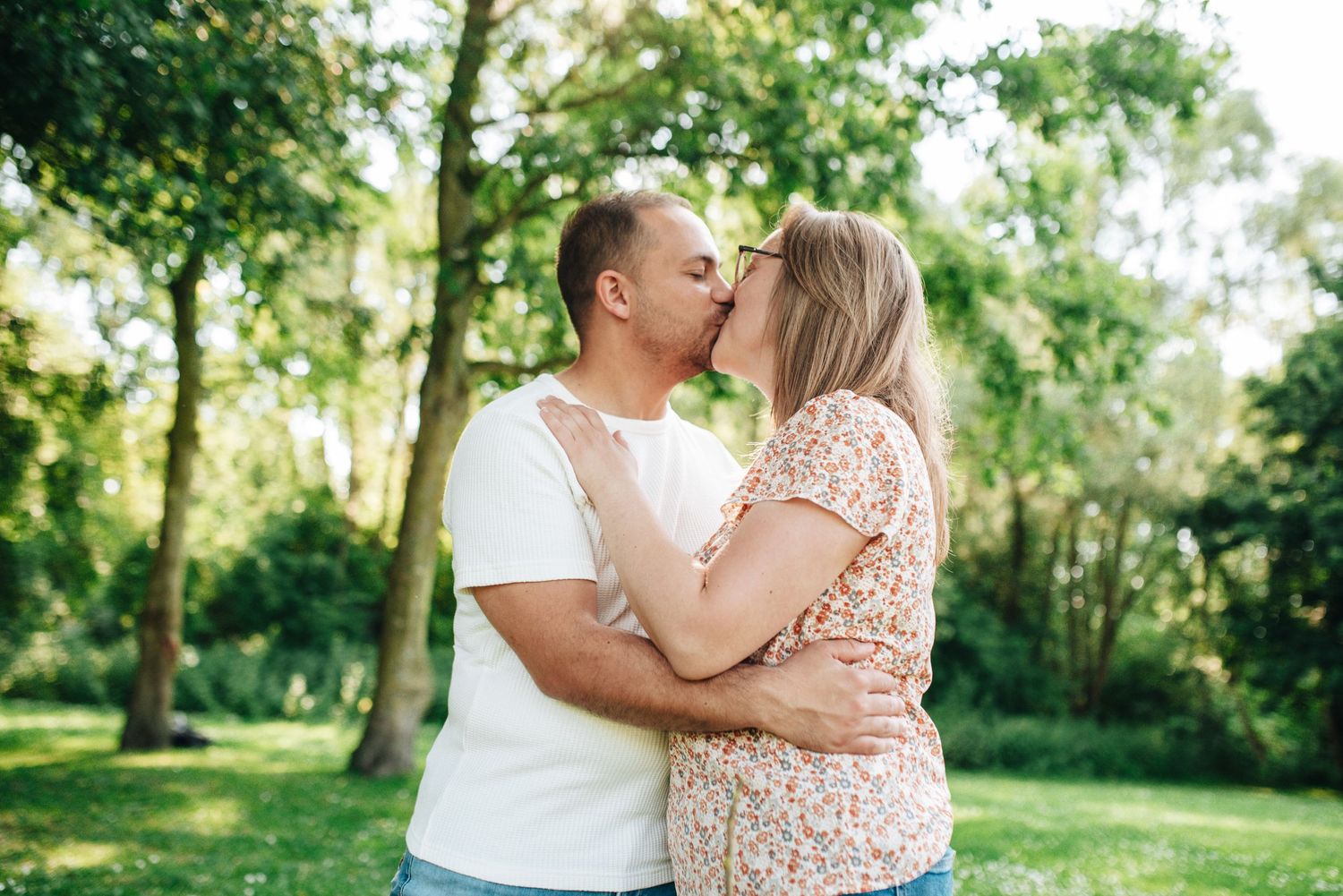Romantic outdoor photo sequence of a couple sharing intimate moments in a sunlit wooded area.