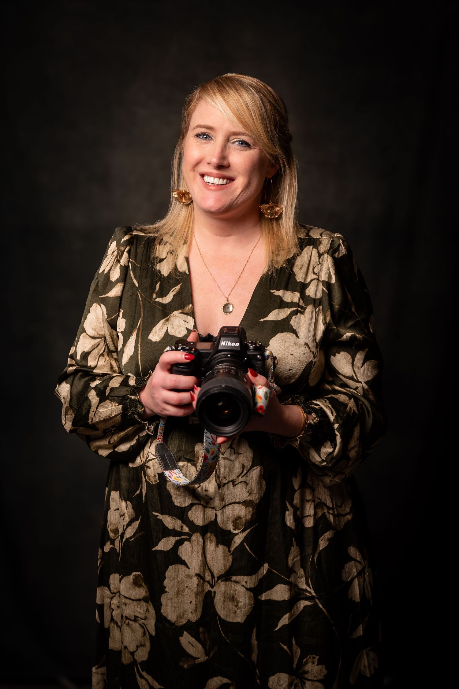 Studio photography session with floral print outfit against dark background.