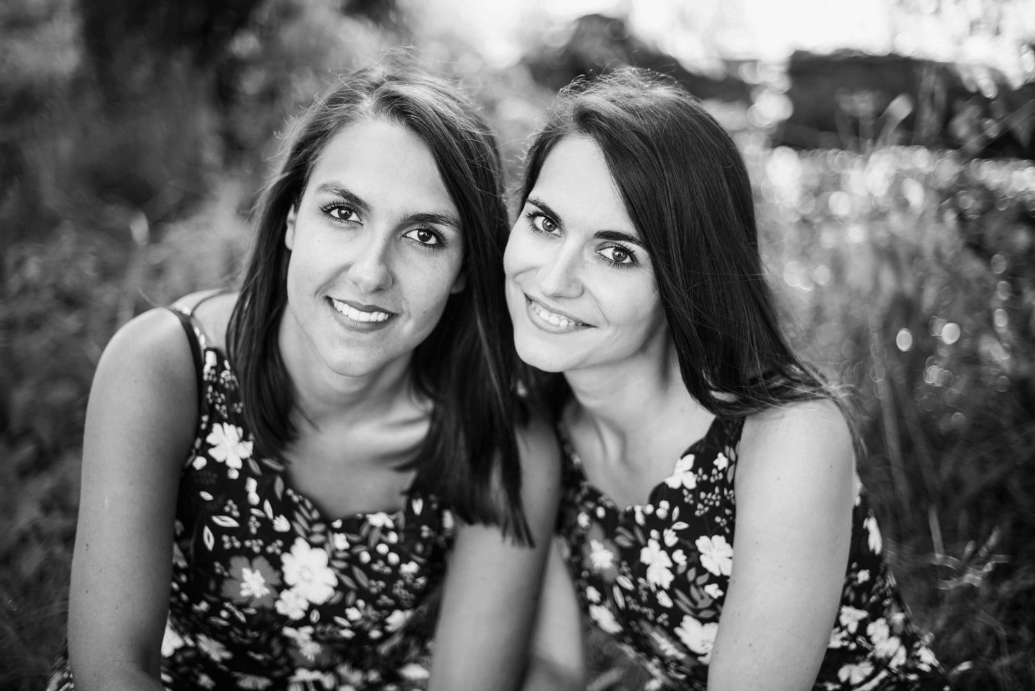 Sisters sharing joyful moments during outdoor portrait session.