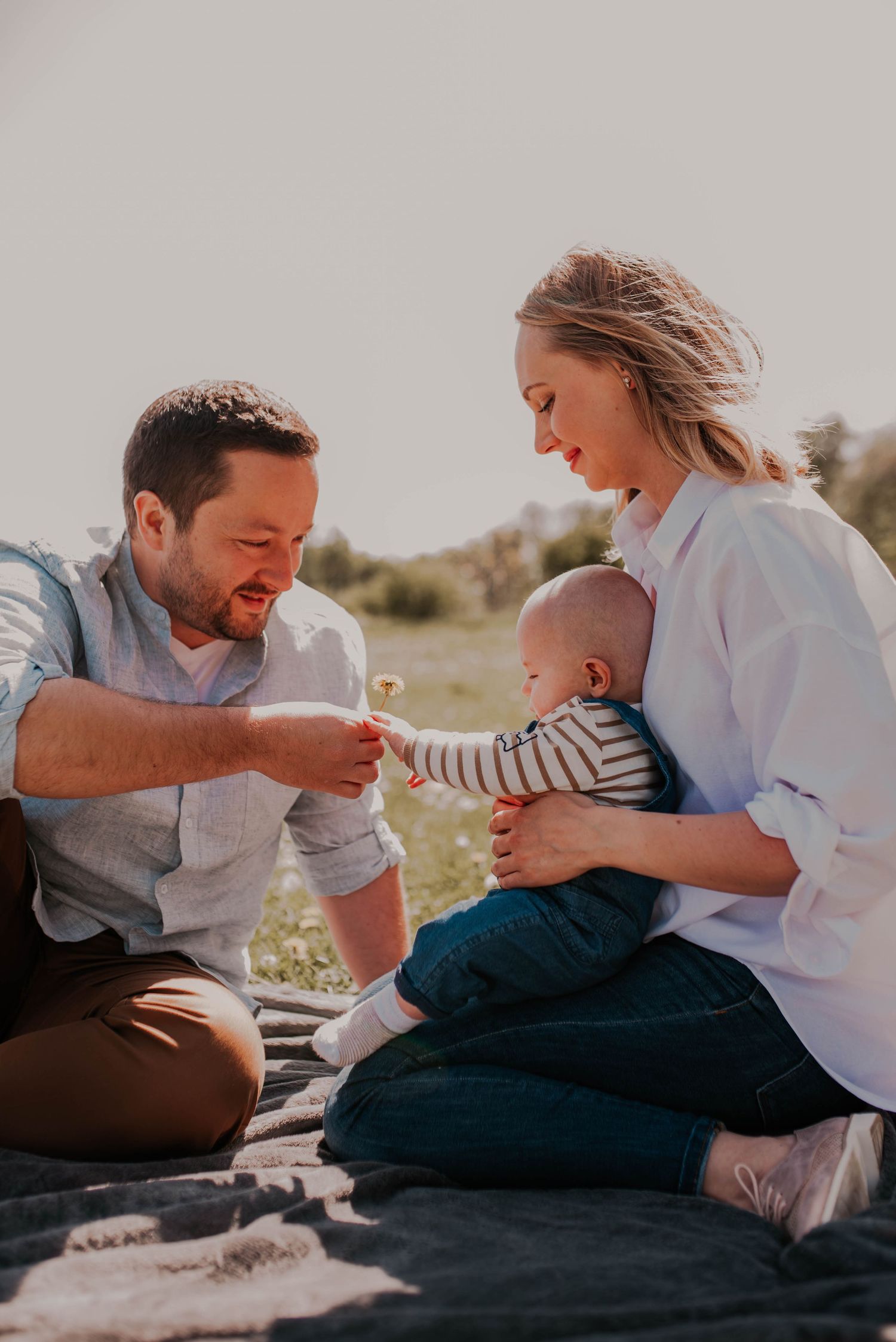 Candid moments of family playtime captured during outdoor photoshoot in natural light.