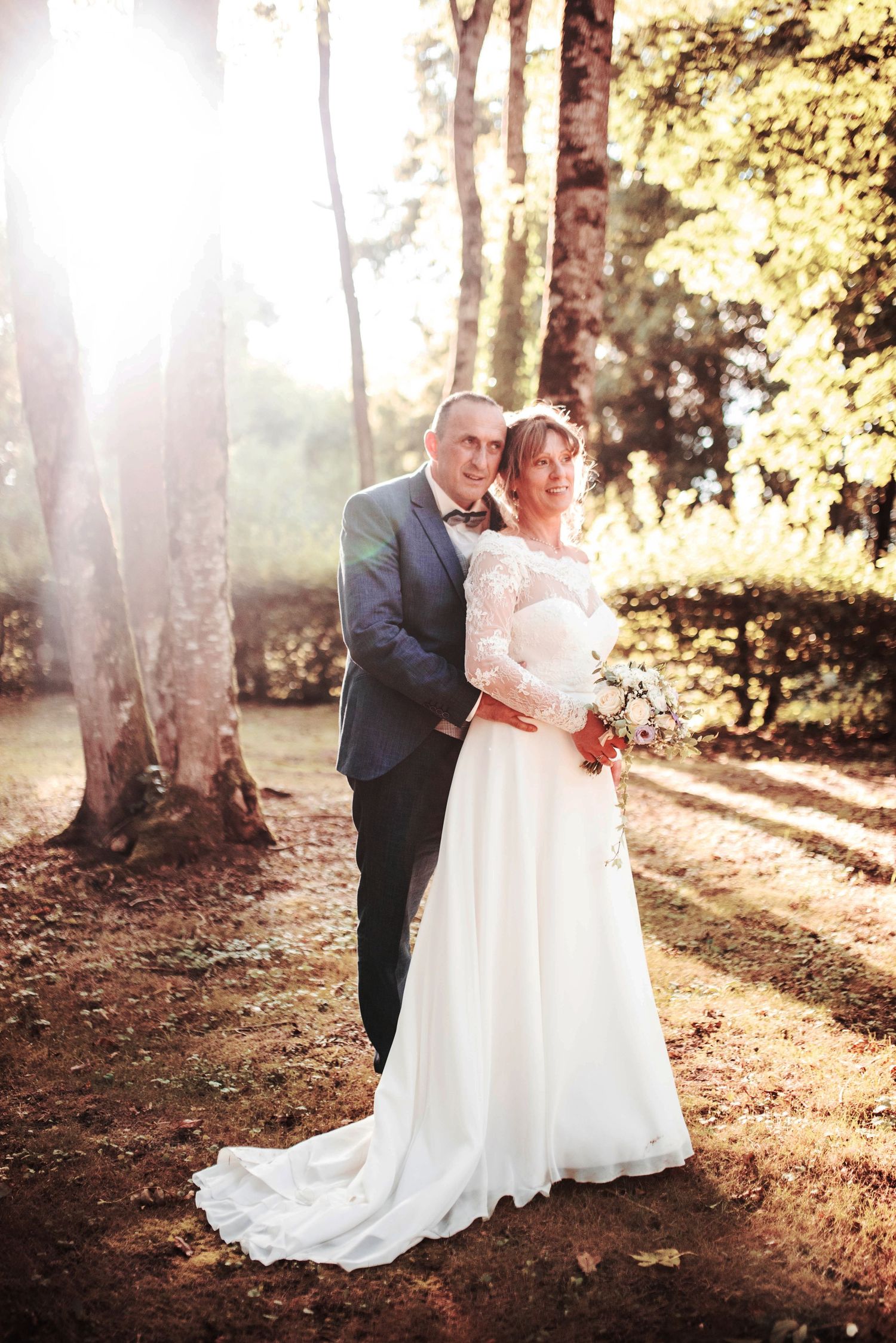Sunlit forest wedding photos with golden light filtering through trees.