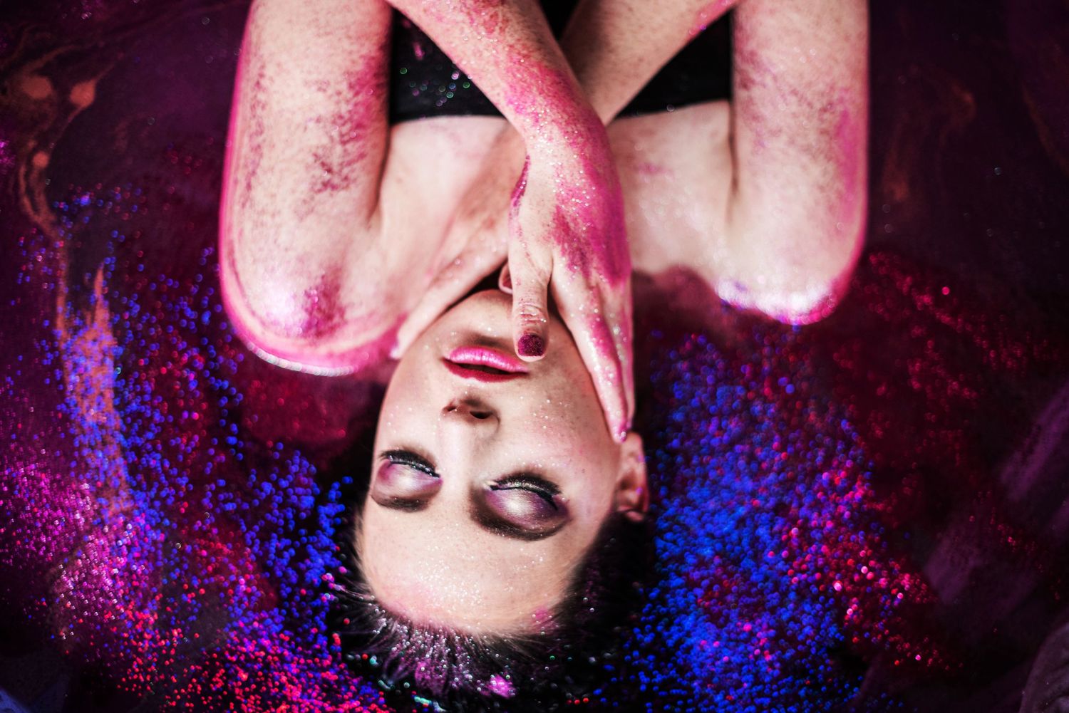 Artistic portrait with vibrant pink and blue light effects creating a dreamy atmosphere.
