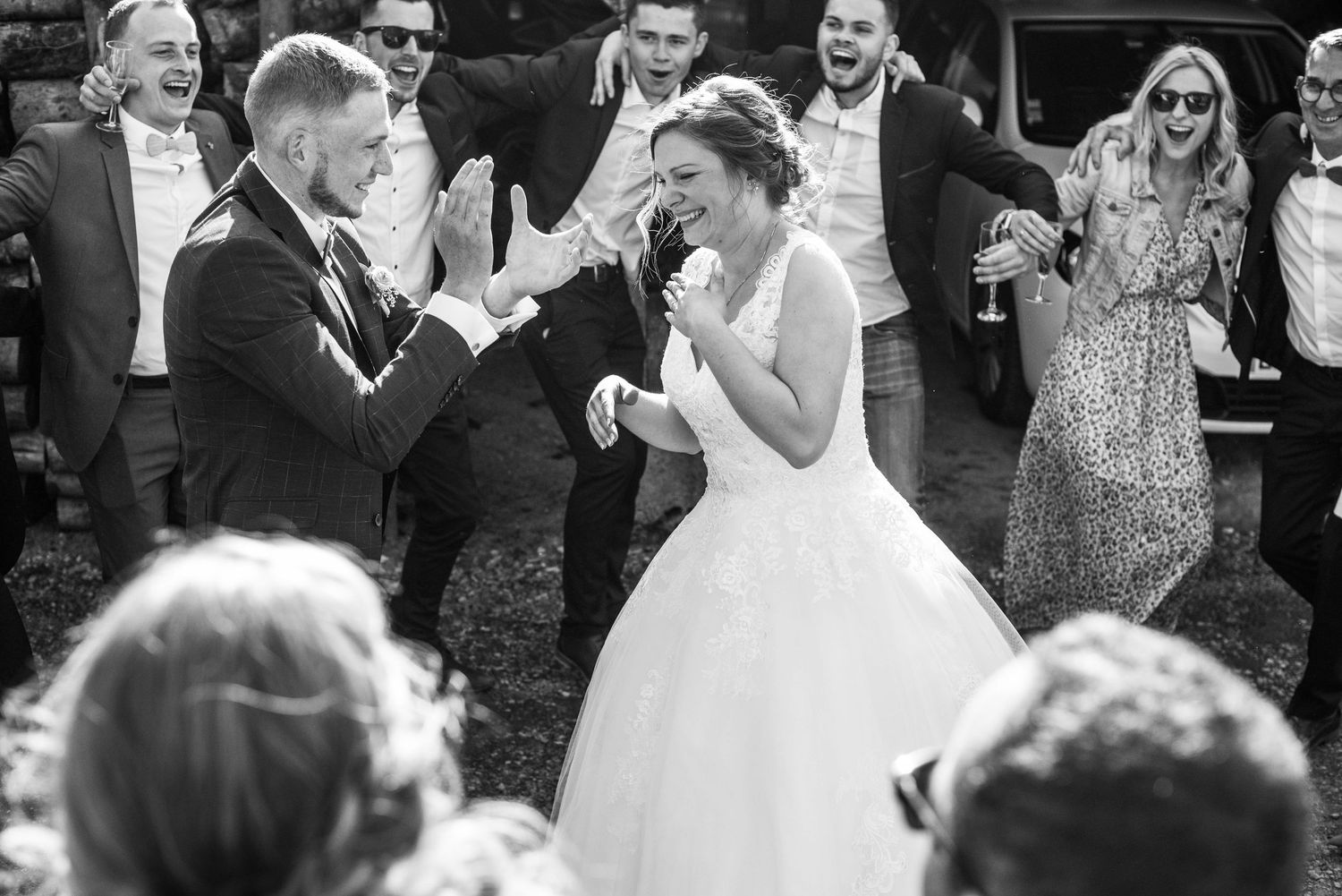 Wedding guests dance and celebrate on an outdoor dance floor during a lively reception.