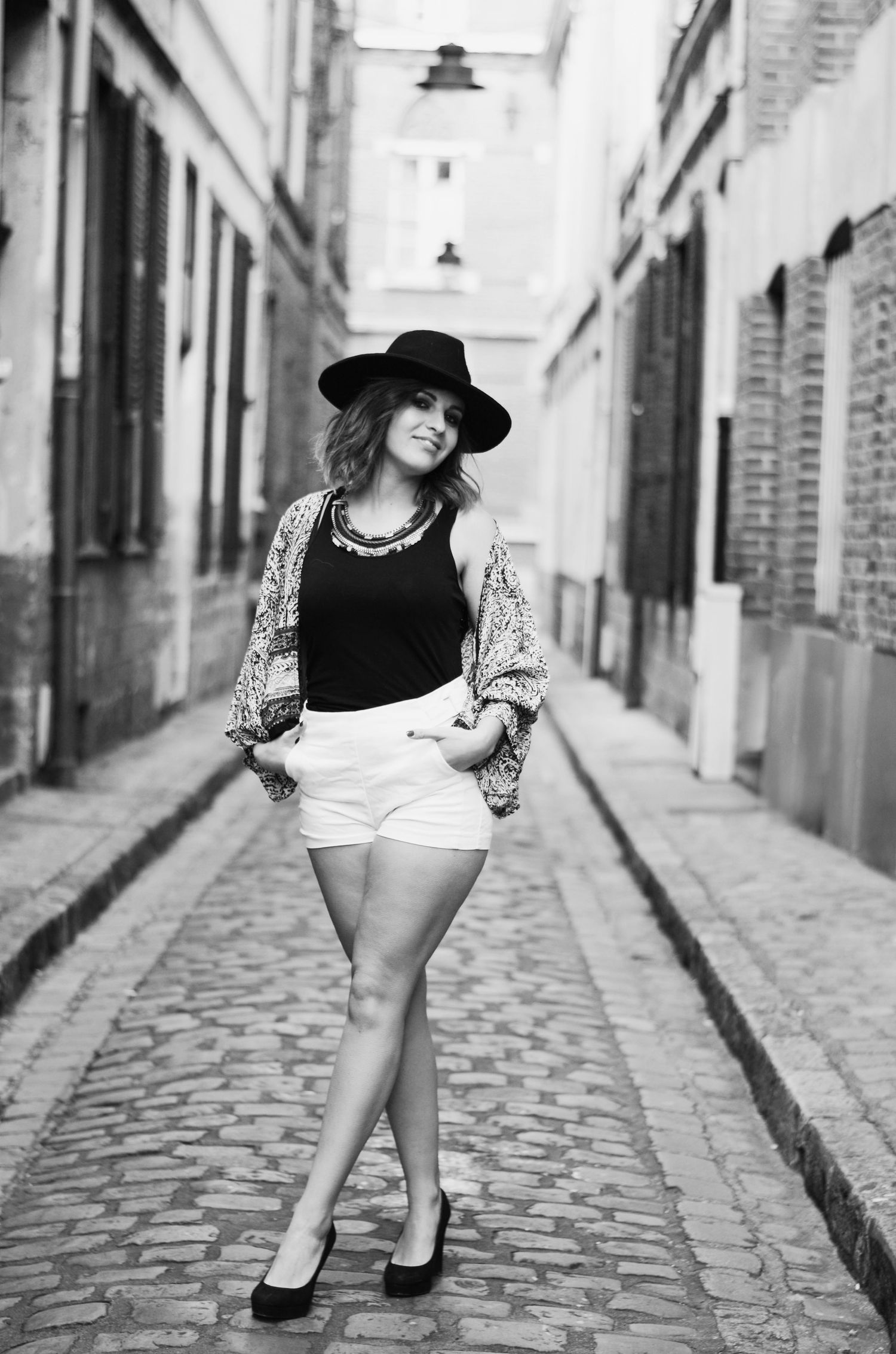 Black and white street style photo on cobblestone alley featuring summer casual wear.