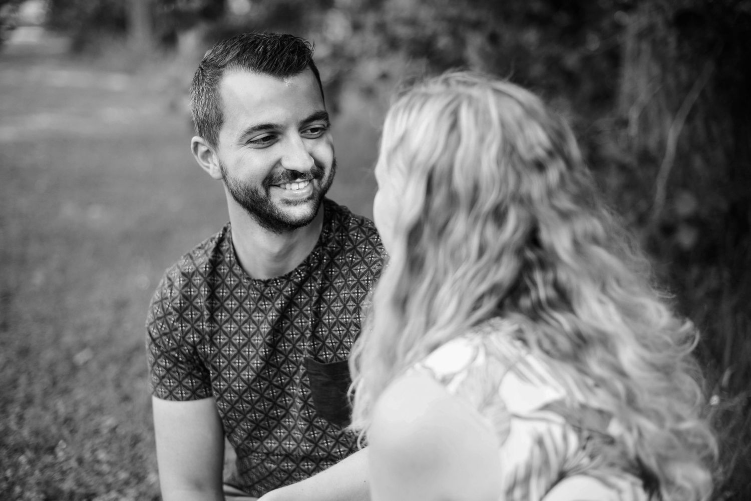 Romantic couple sharing intimate moments in a black and white outdoor photo sequence.
