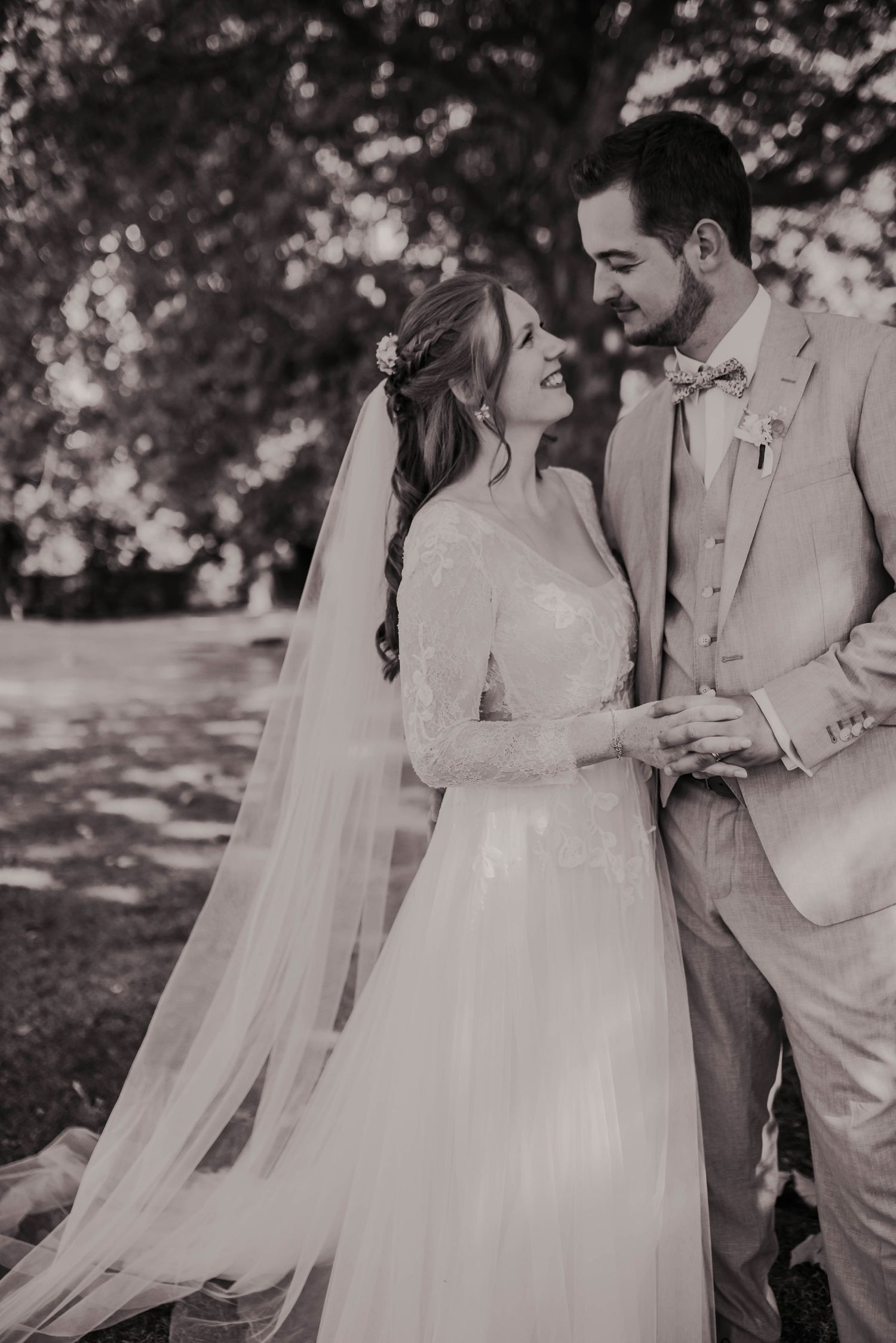 Wedding couple in a romantic outdoor photoshoot with flowing white dress and veil.