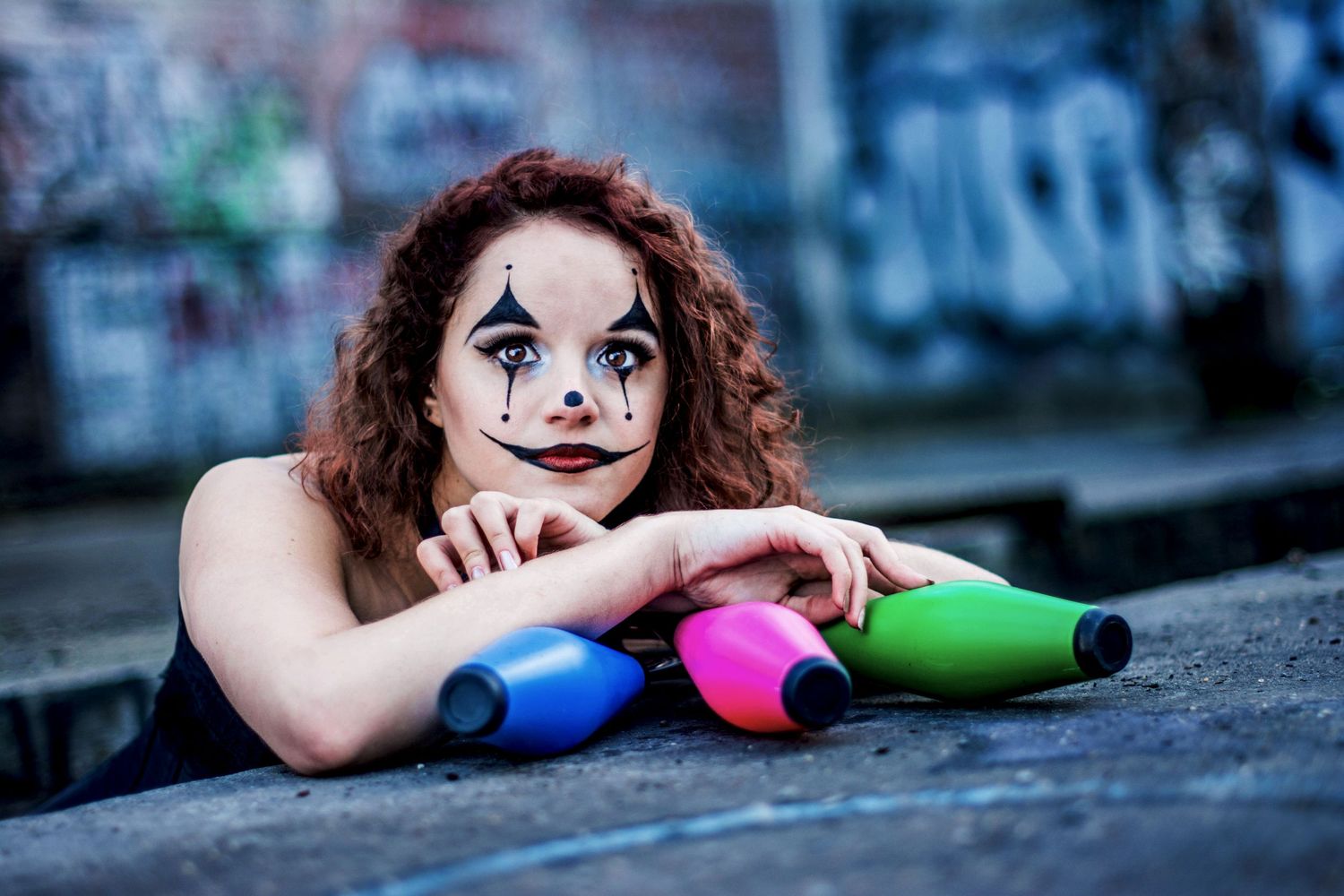 Artistic portrait series with theatrical clown makeup against blue background.