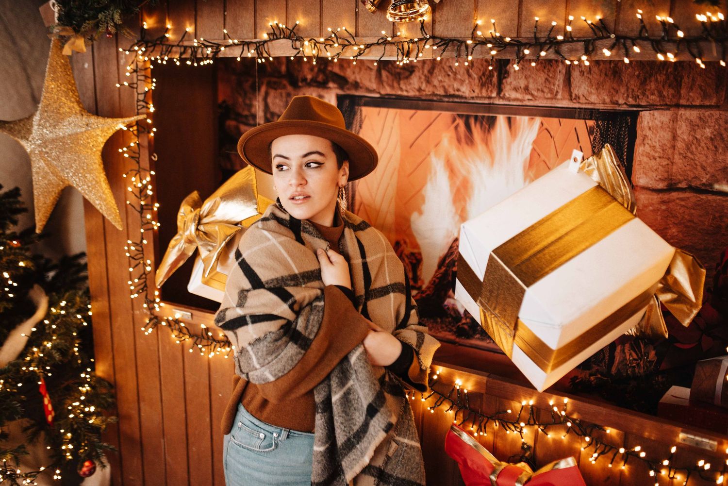 A cozy library setting decorated with warm string lights and holiday decorations.