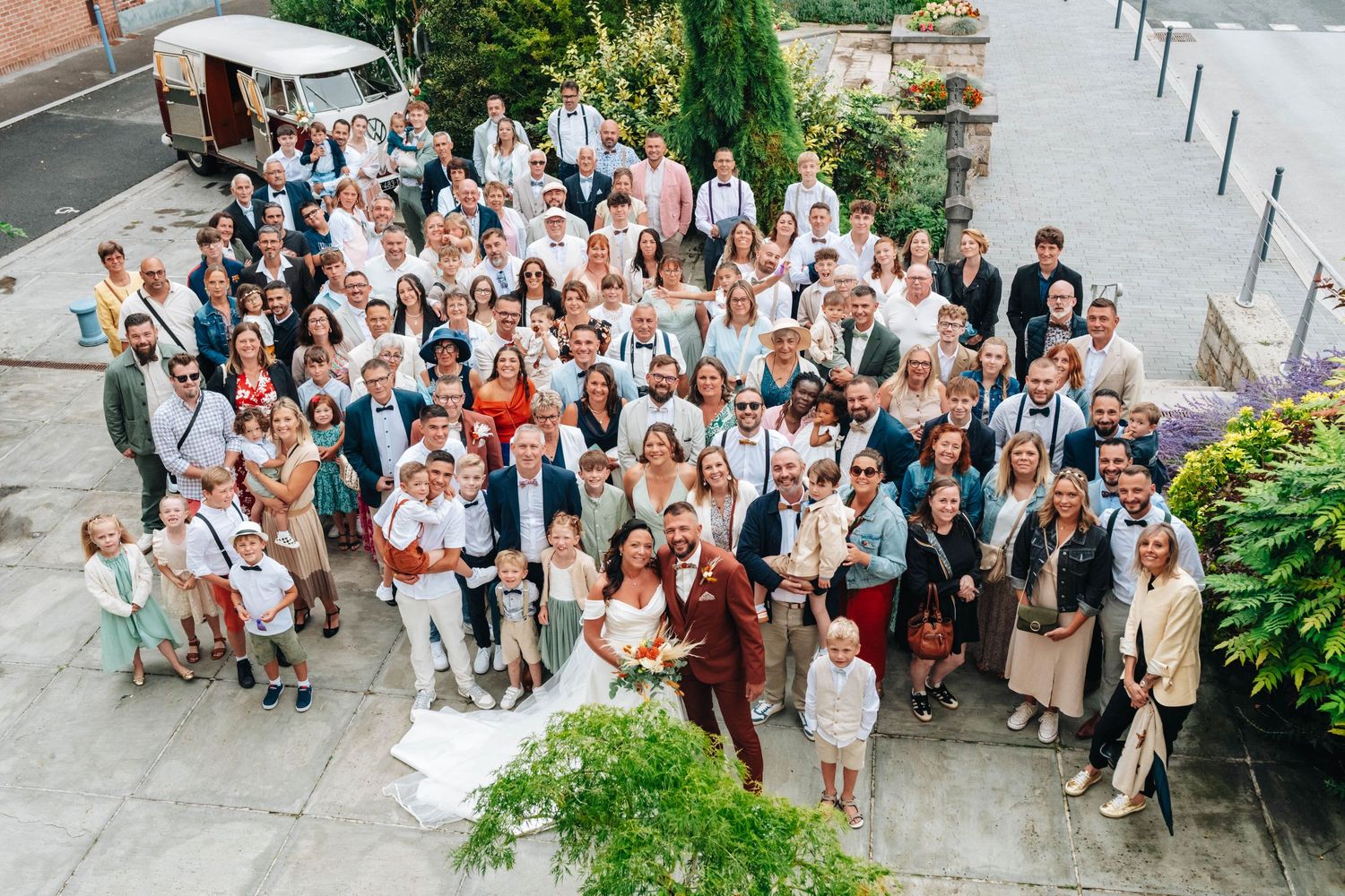 Large group photo of wedding guests gathered outside on stone steps.