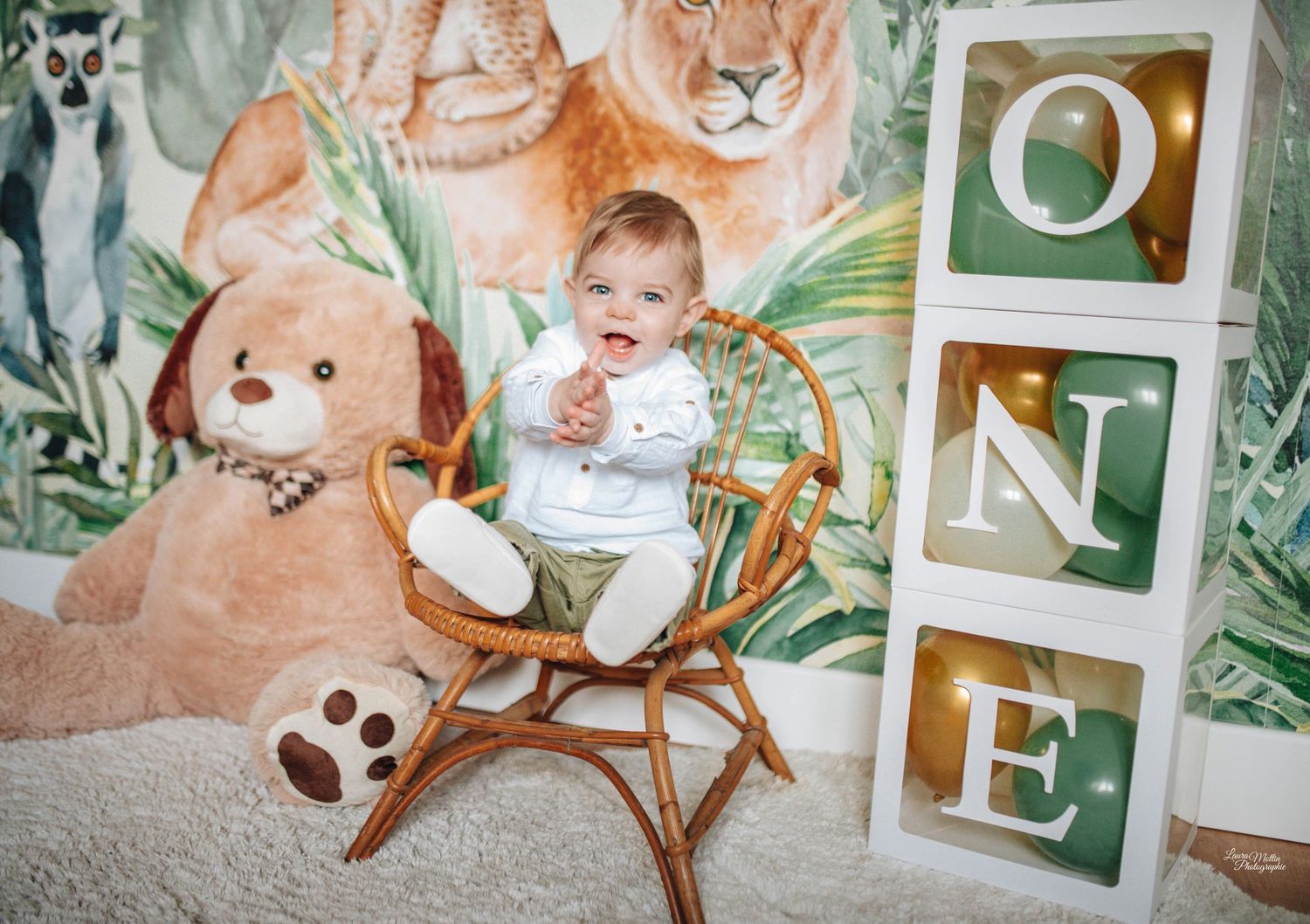 Baby nursery scene with stuffed animals, polaroid photos and woodland decorations.