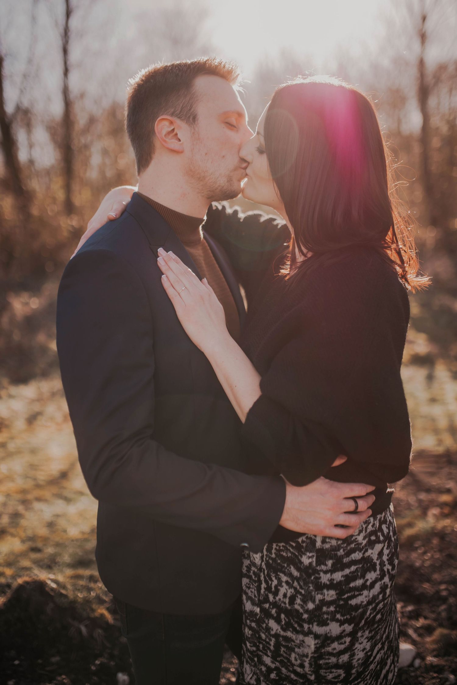 Romantic sunset engagement photoshoot in autumn woods with dramatic lighting.