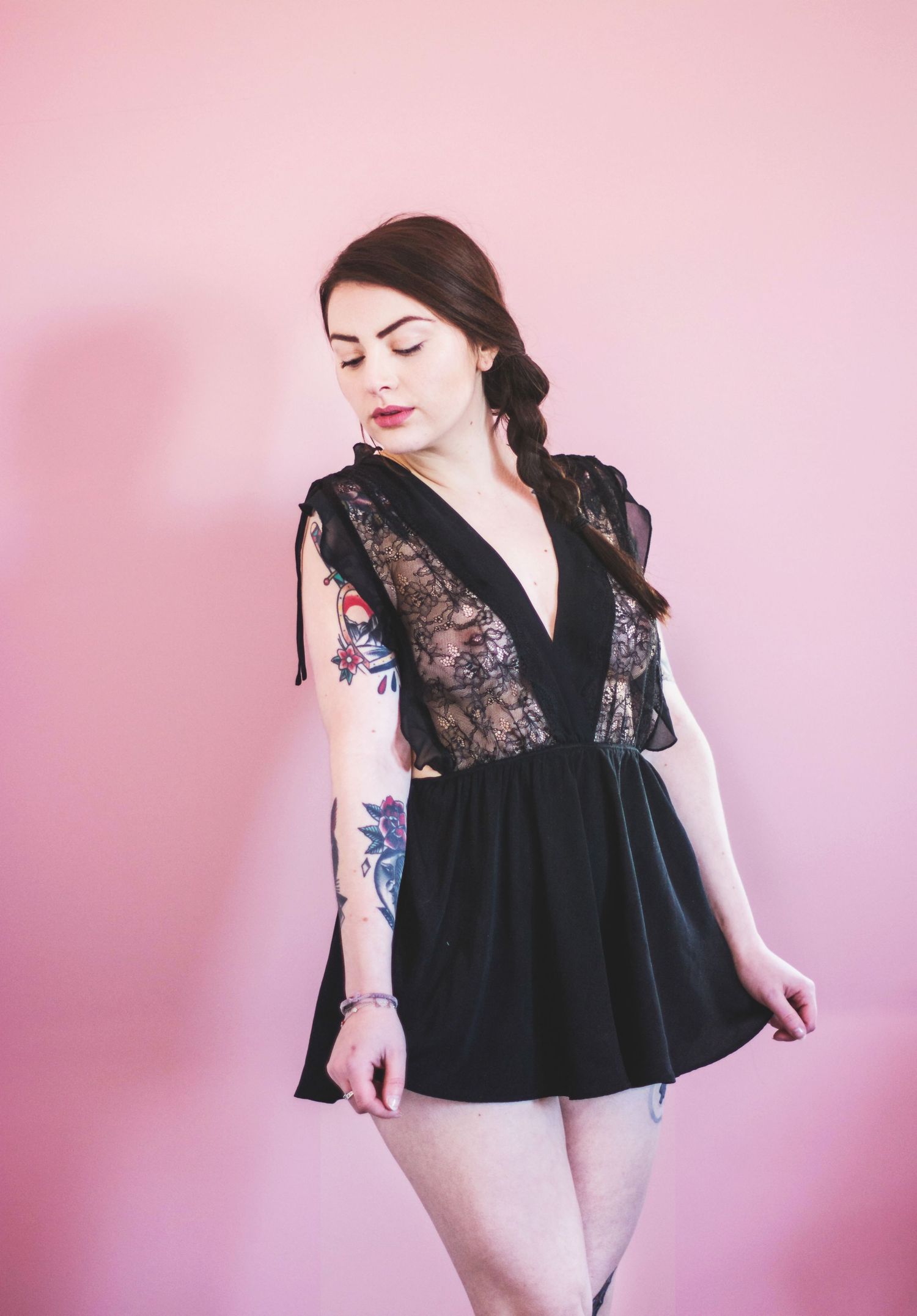 Fashion portraits against pink background showing black lace clothing details.