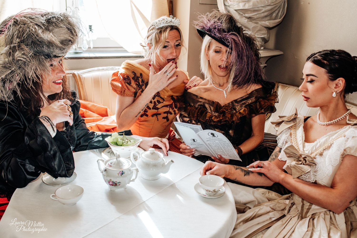 Friends enjoying tea and treats at an elegant vintage-themed gathering.