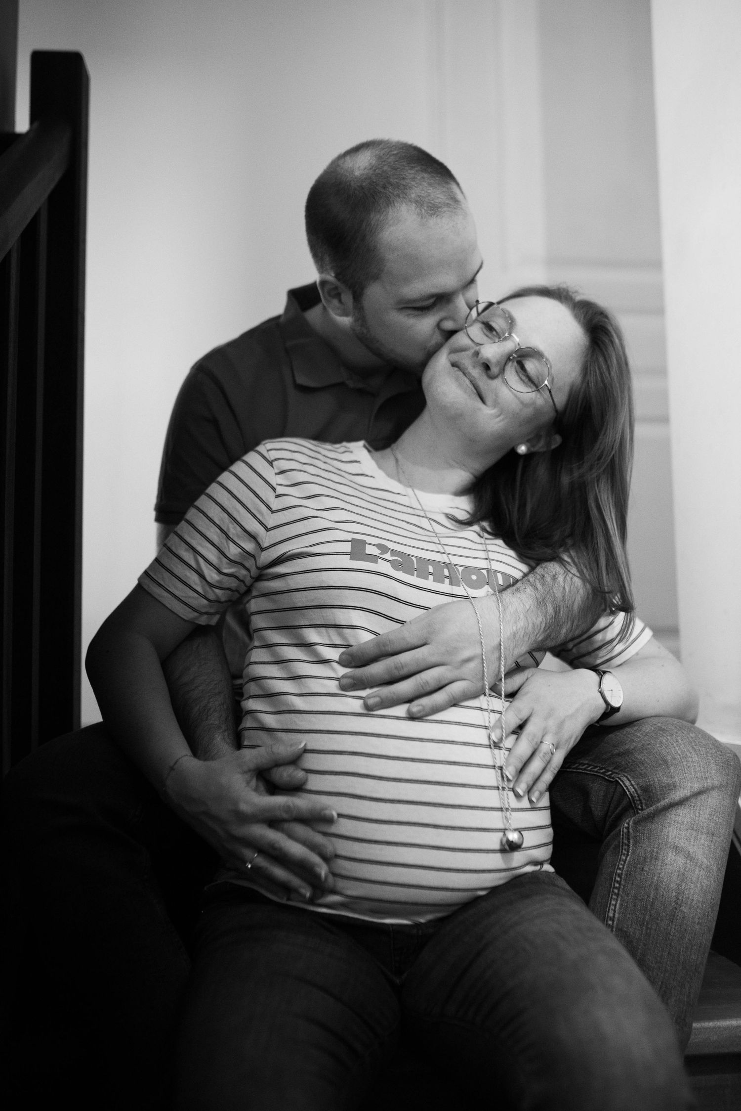 Black and white intimate maternity photos showing tender moments between a couple.