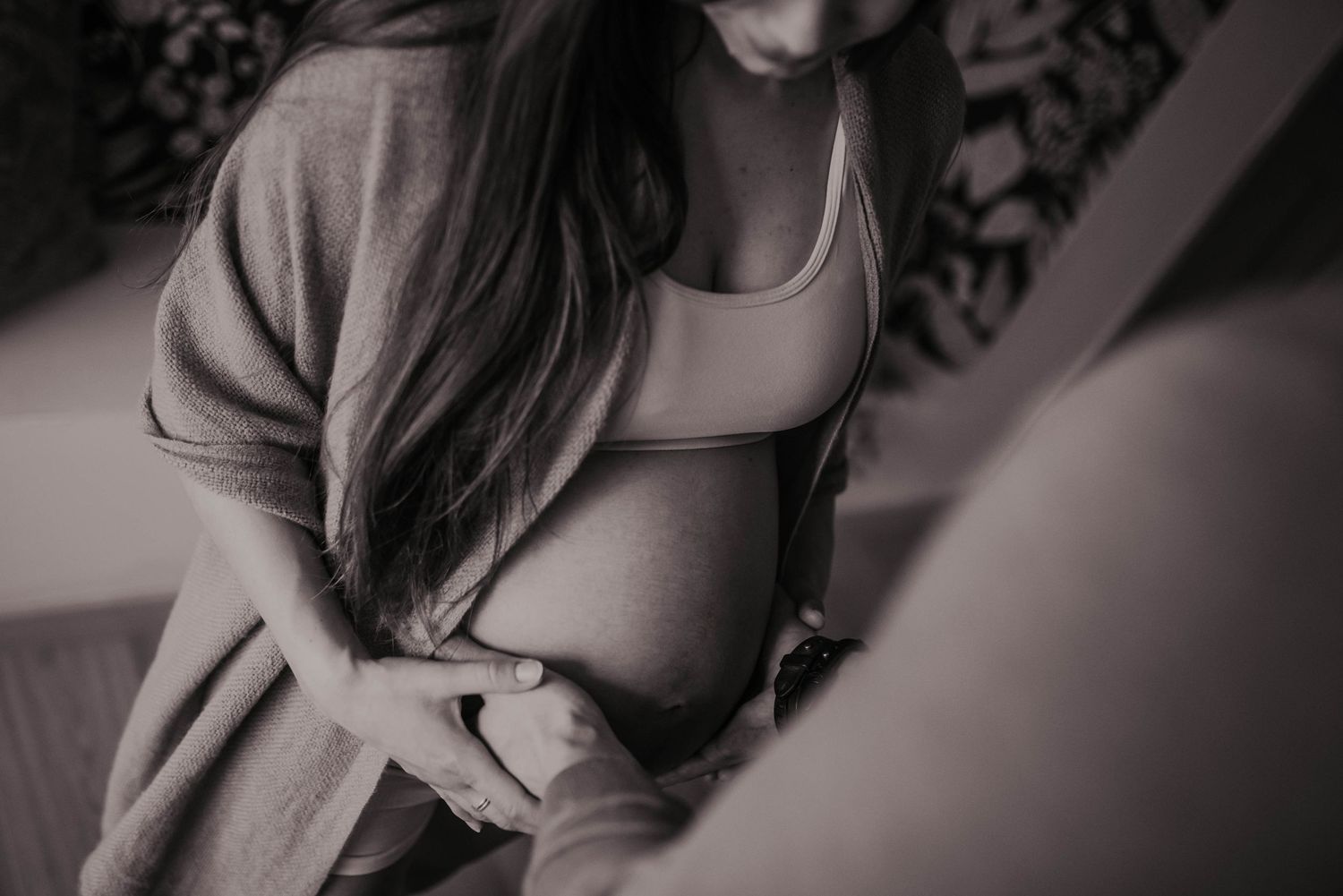 Artistic black and white maternity photography with moody lighting.