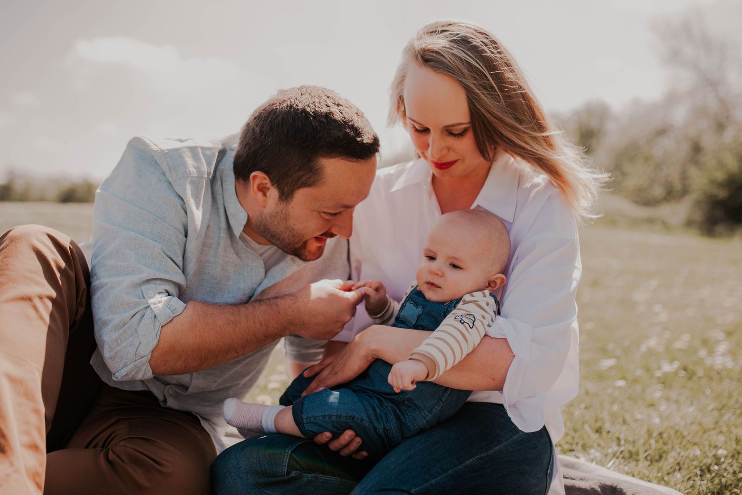 Sweet candid moments of a family playing together on grass.