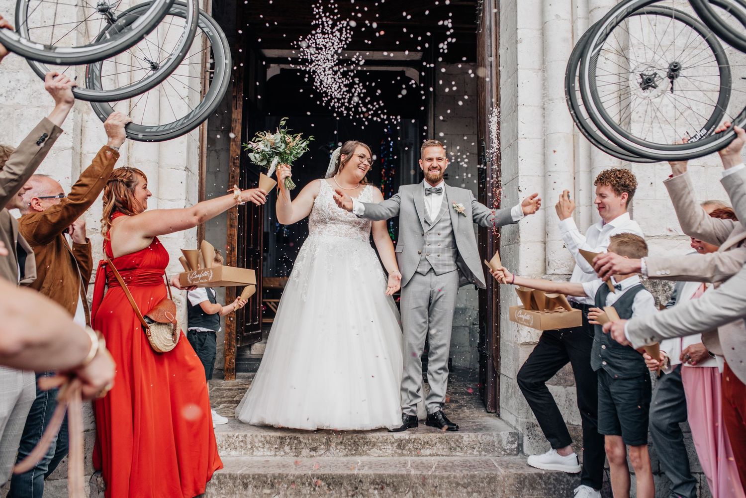 Wedding party celebrating outside church with rice being thrown in celebration.