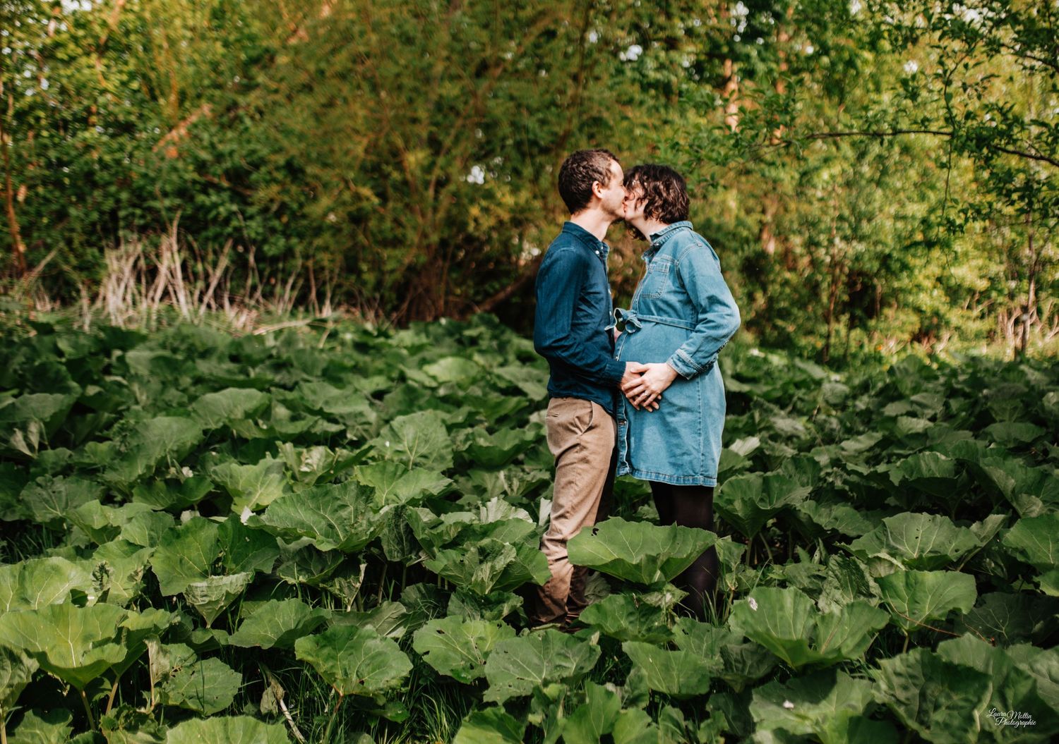 Romantic couple embracing among green garden plants on a sunny day.