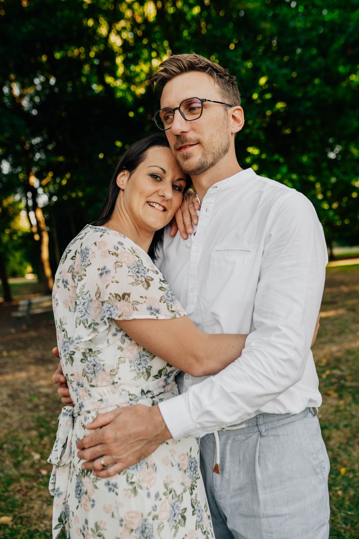 Romantic couple portraits in garden setting with floral dress and white shirt.