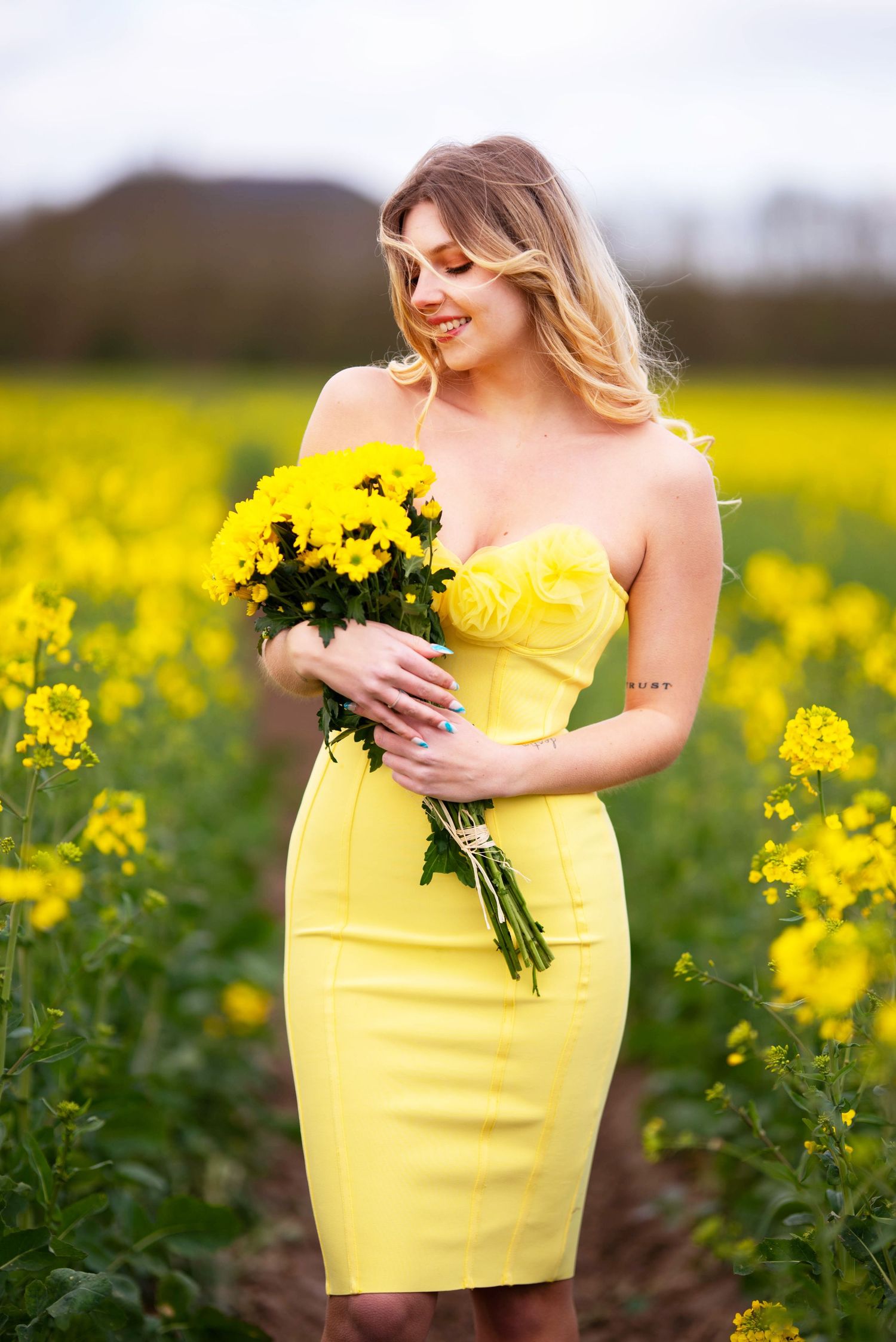 Yellow dress contrasts beautifully against a field of blooming canola flowers.
