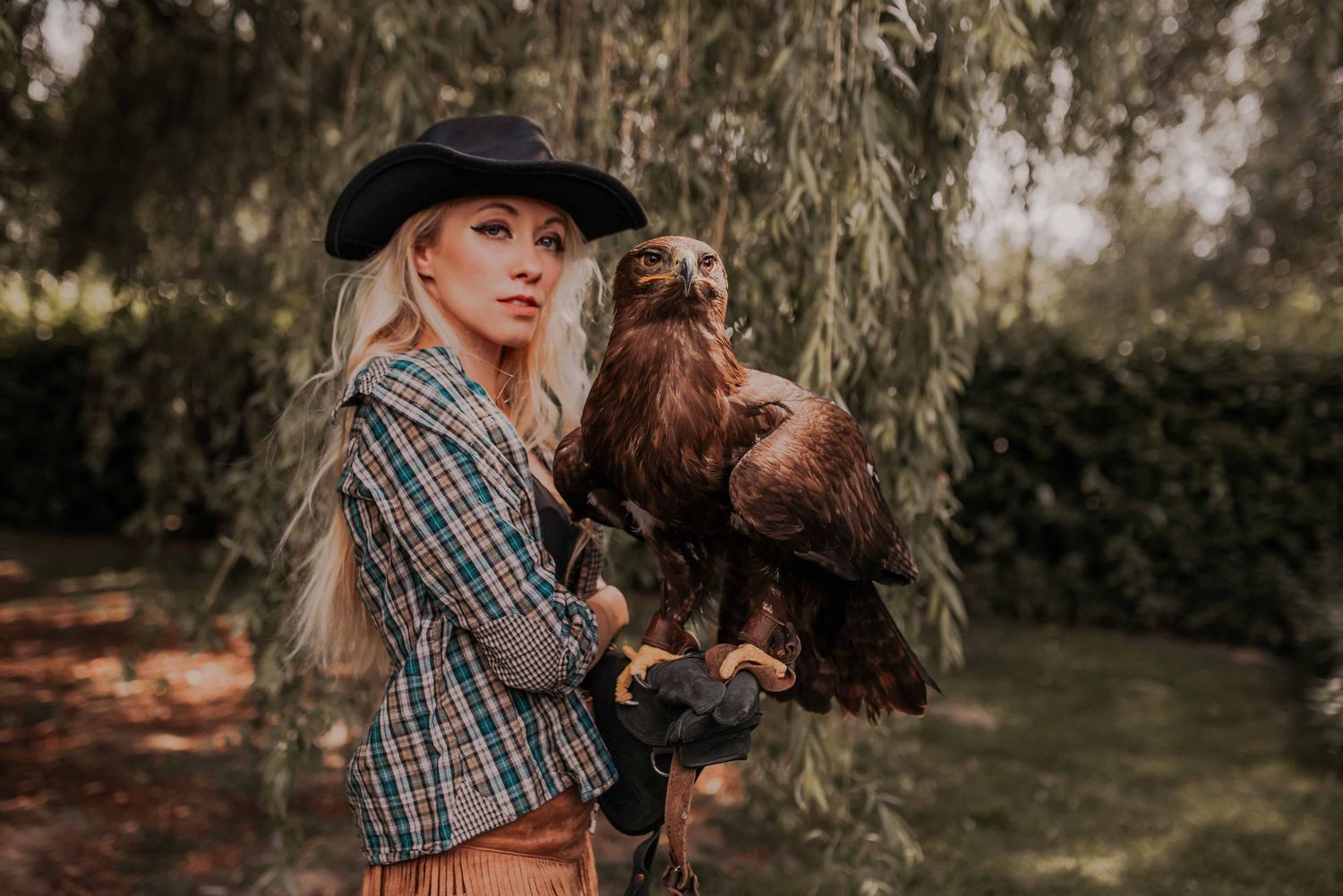 Falconry demonstration with birds of prey against natural woodland backdrop.