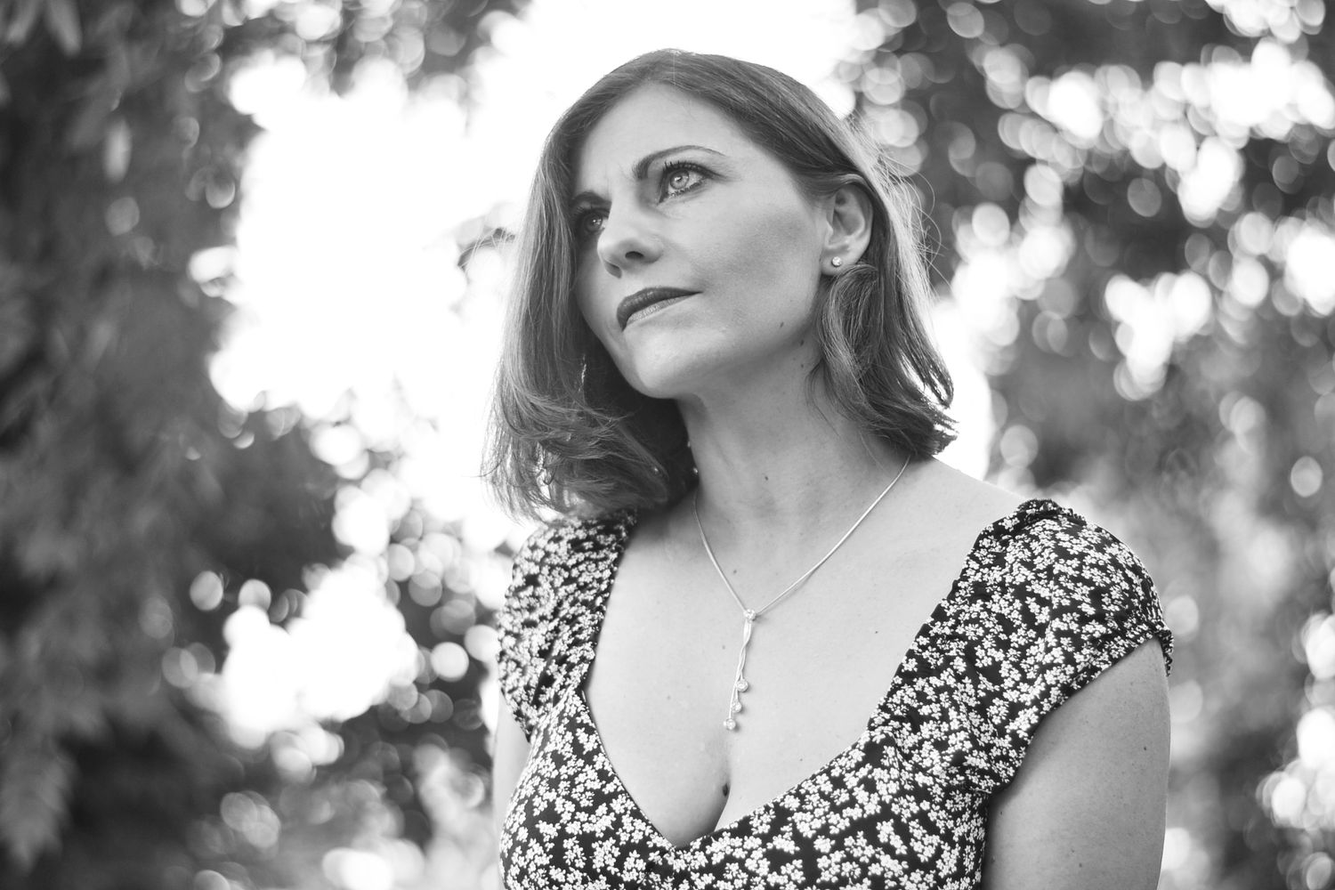 Black and white outdoor portrait series with bokeh background effects.