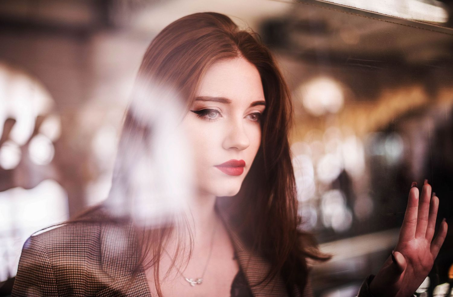 An atmospheric portrait with soft lighting and reflective elements creating a dreamy effect.