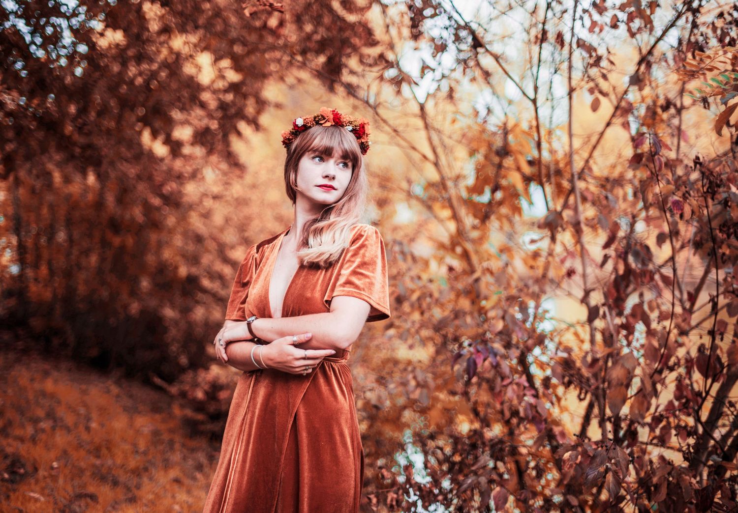 A series of warm autumn-toned photos showing a person in a rust-colored dress among fall foliage.