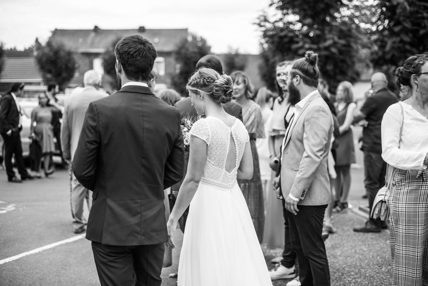 Wedding guests gather outdoors for a reception celebration in vintage black and white style.