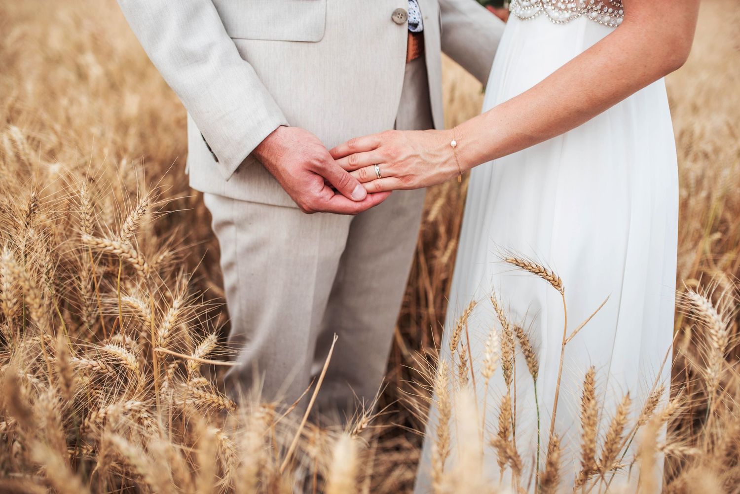 A romantic moment captured as a couple embraces in a golden wheat field at sunset.